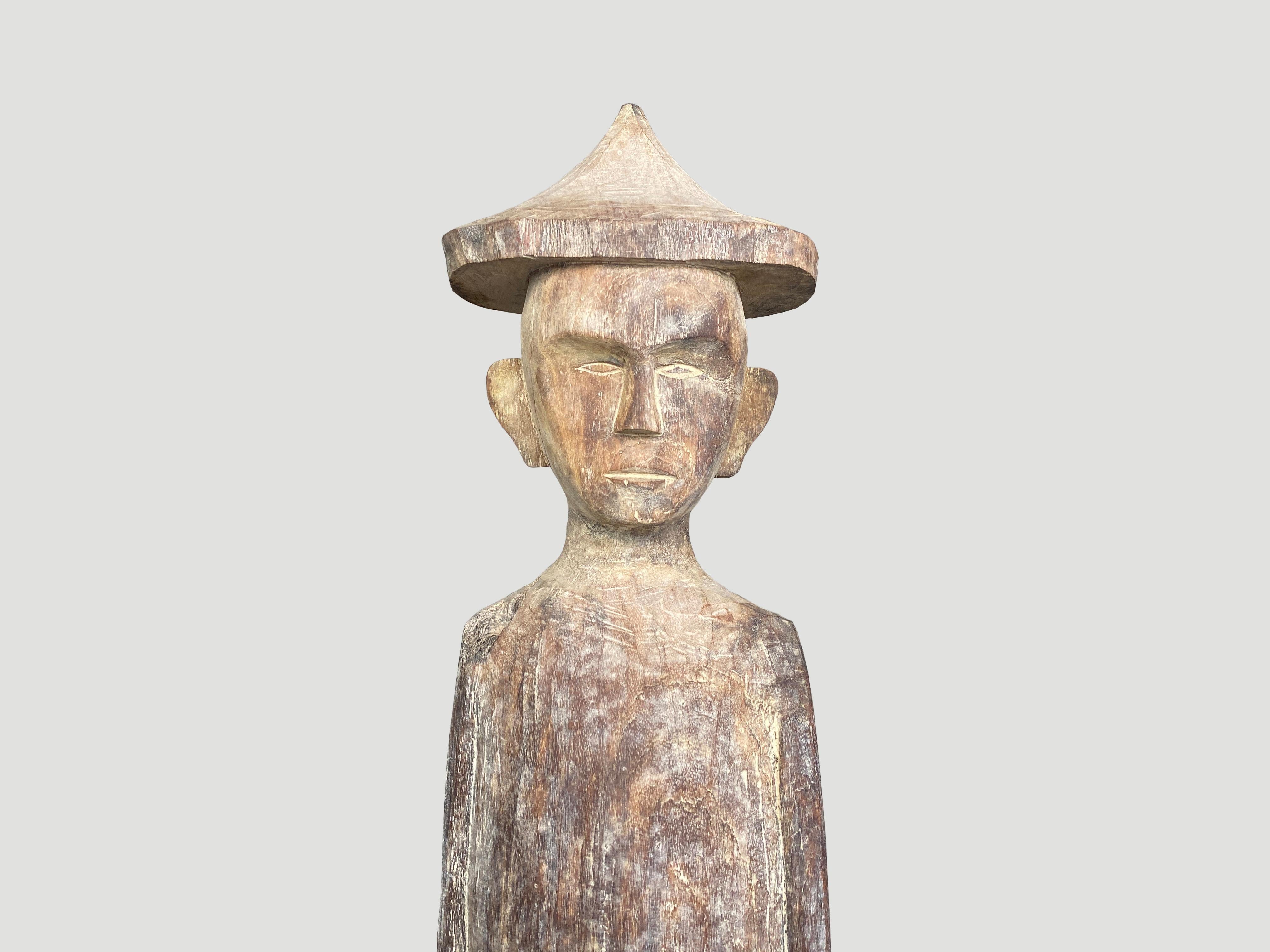 Impressive antique male statue hand carved from a single wood log with beautiful carvings from West Borneo. Originally used to protect the home from evil spirits and placed into the ground in front of the house as a guardian. We added a modern metal