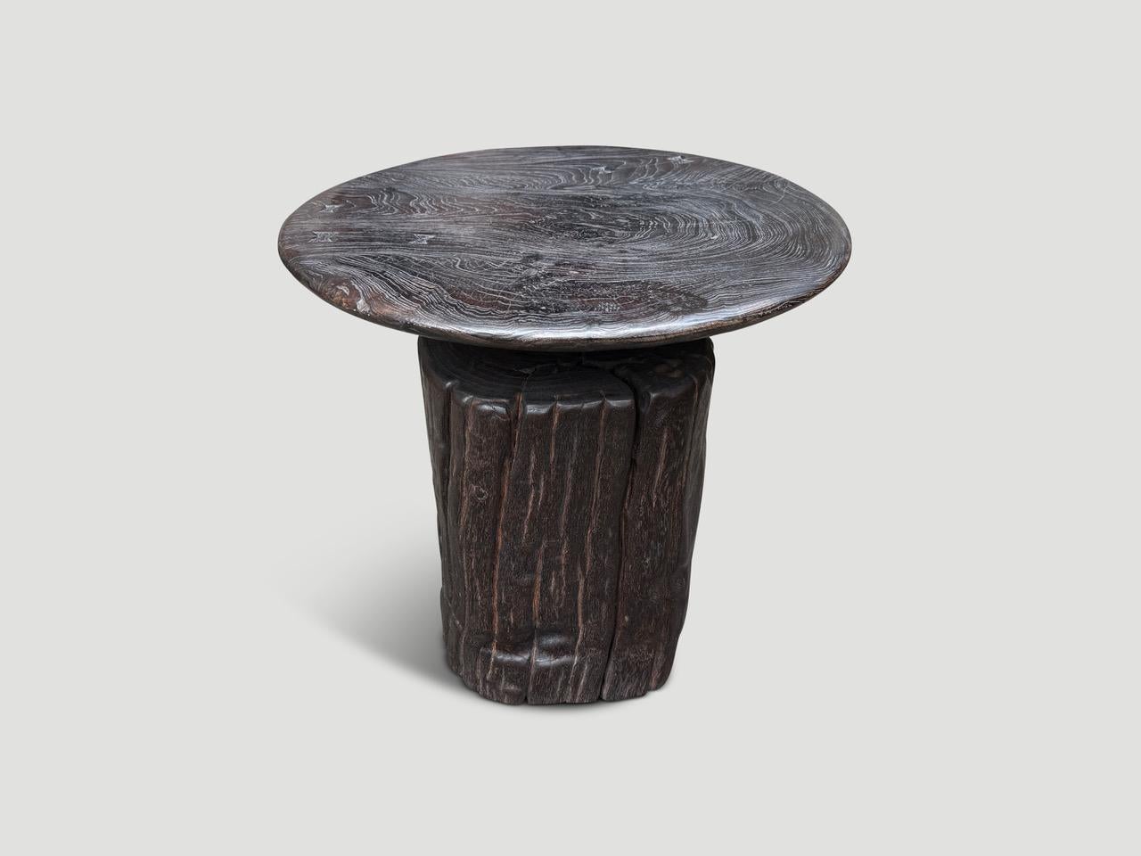 Un mortier centenaire, utilisé à l'origine pour moudre le riz, a été reconverti en une table d'appoint ou d'entrée unique. Nous avons ajouté un simple plateau rond biseauté en teck épais et une teinture chocolat révélant le magnifique veinage du