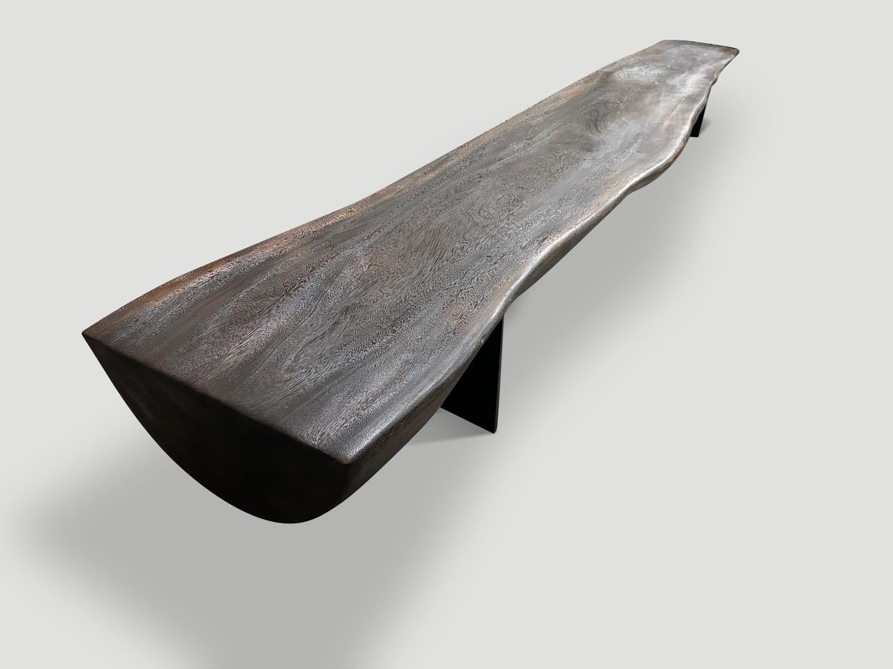 A beautiful suar wood reclaimed log has been cut in half to produce this dramatic long bench with a live edge from 22” to 14” wide. We added sleek minimalist steel legs in contrast to this ten inch thick log. Lightly charred revealing the unique