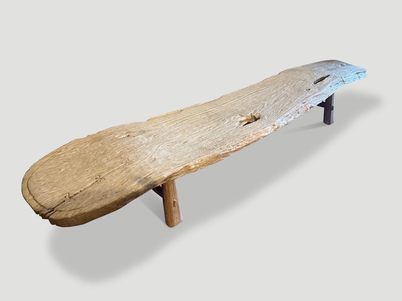 Una impresionante plancha de madera de teca de un siglo de antigüedad se ha convertido en este banco largo o chaise longue único en su especie. Tanto utilizable como escultural. Añadimos patas de estilo de mediados de siglo en contraste con la parte