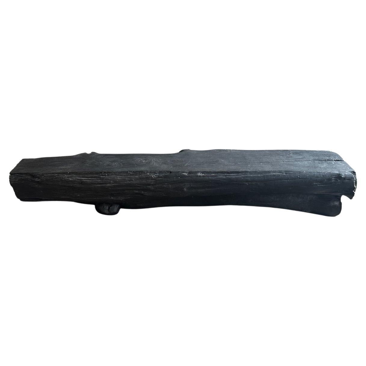 Impressive sculptural log style teak wood bench. The live edge varies from 12” deep on one end, center 20” and 18” deep. Both functional and sculptural. It is rare to find ancient teak wood this size. Charred, revealing the unique wood grain. It’s
