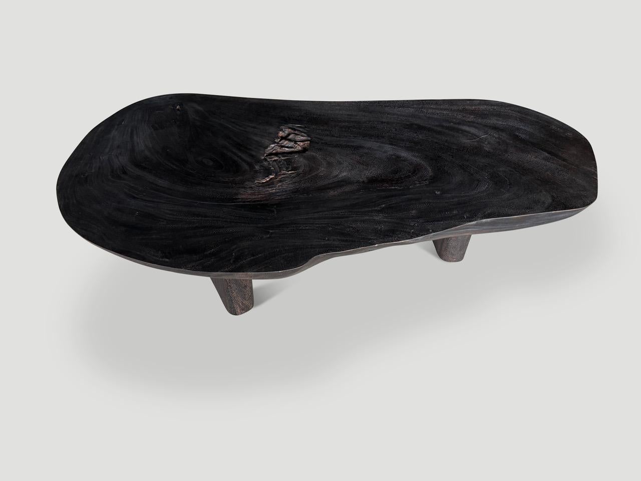 Impressive reclaimed four inch slab suar wood coffee table, floating on three minimalist legs. Charred, sanded and sealed revealing the beautiful wood grain. Full dimensions; 69” wide x 38” to 28” deep x 16” high. 

The Triple Burnt Collection