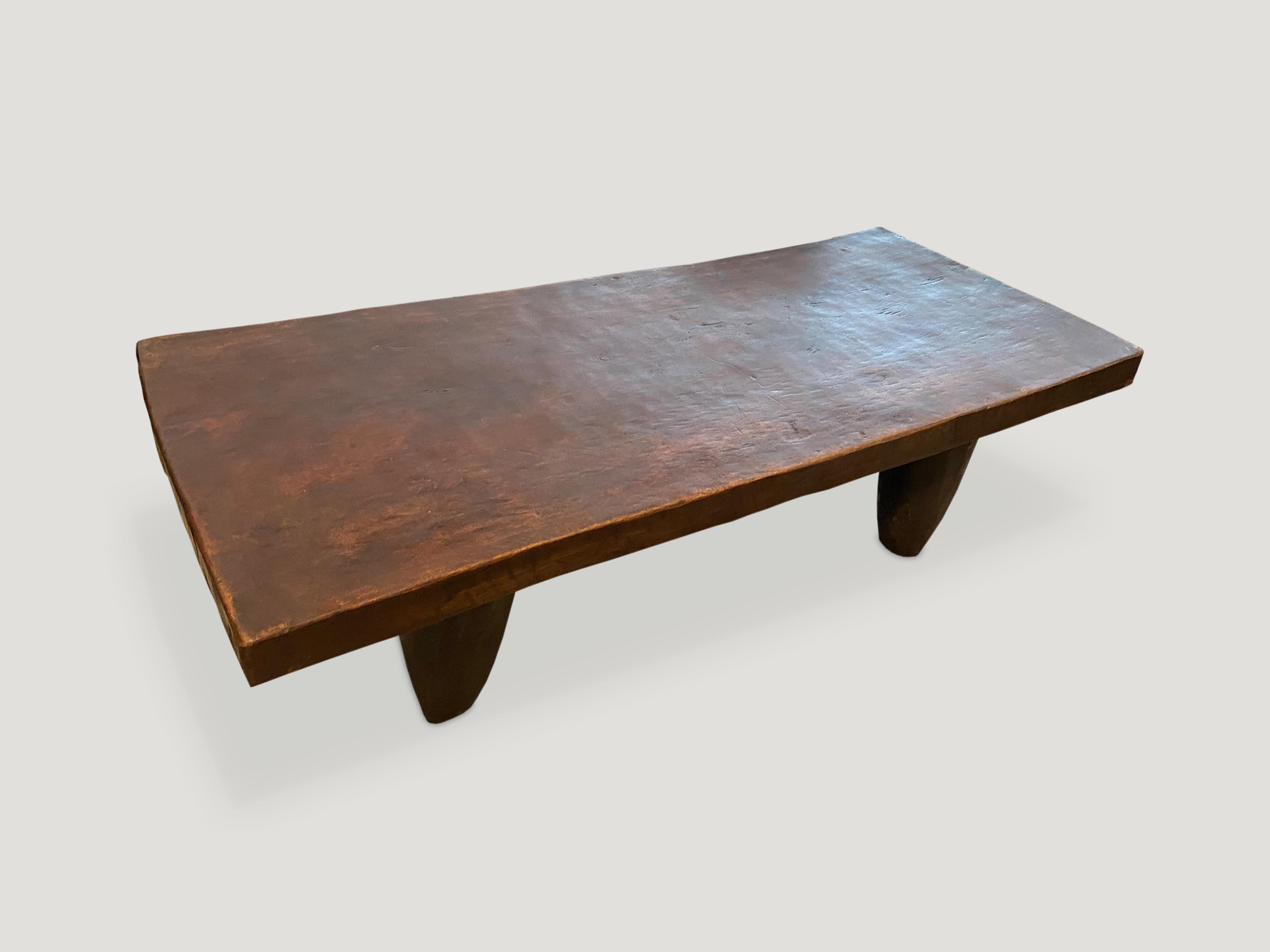 Antique coffee table or bench carved from a single piece of iroko wood, native to the west coast of Africa. The wood is tough, dense and very durable. A single two inch thick slab coffee table or bench with cone style legs.

This coffee table or