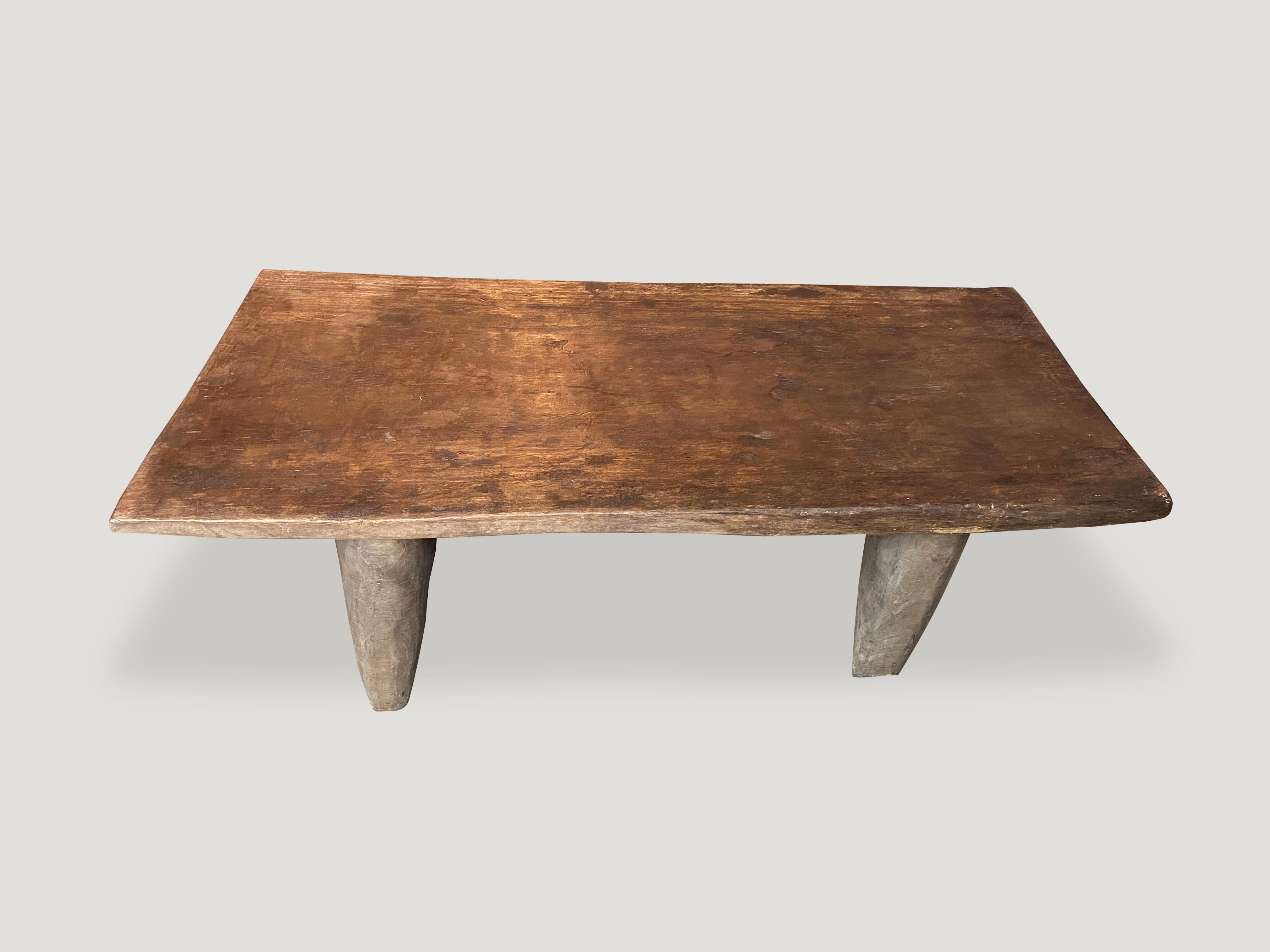 Antique bench or coffee table hand carved by the Senufo tribes from a single block of iroko wood, native to the west coast of Africa. The wood is tough, dense and very durable. Shown with cone style legs.

This bench or coffee table was sourced in