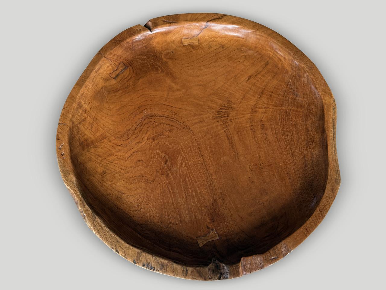Preciosa raíz de teca centenaria con forma de mesa auxiliar. Tallamos a mano la parte superior en forma de bandeja y añadimos el detalle de la mariposa incrustada. Pulido con un aceite natural que revela la veta única de la madera. Tanto utilizable