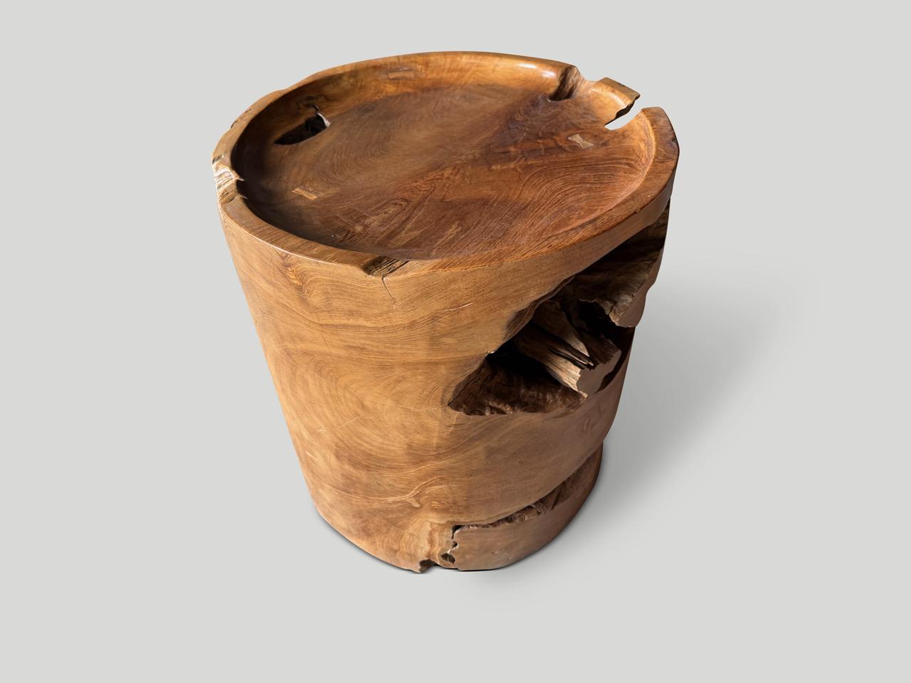 Magnifique racine de teck centenaire façonnée en table d'appoint. Nous avons sculpté à la main la partie supérieure en forme de plateau et ajouté le détail du papillon incrusté. Poli avec une huile naturelle révélant le grain unique du bois. À la
