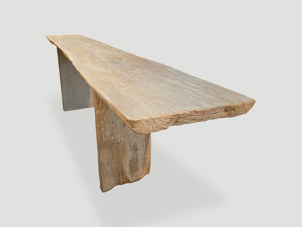 Impressionnante table console en teck blanchi à bord vif et à dalle unique. Nous avons ajouté une légère finition blanche qui révèle le magnifique grain de cette dalle en teck recyclé de 2,5 pouces d'épaisseur. Le plateau repose sur de solides