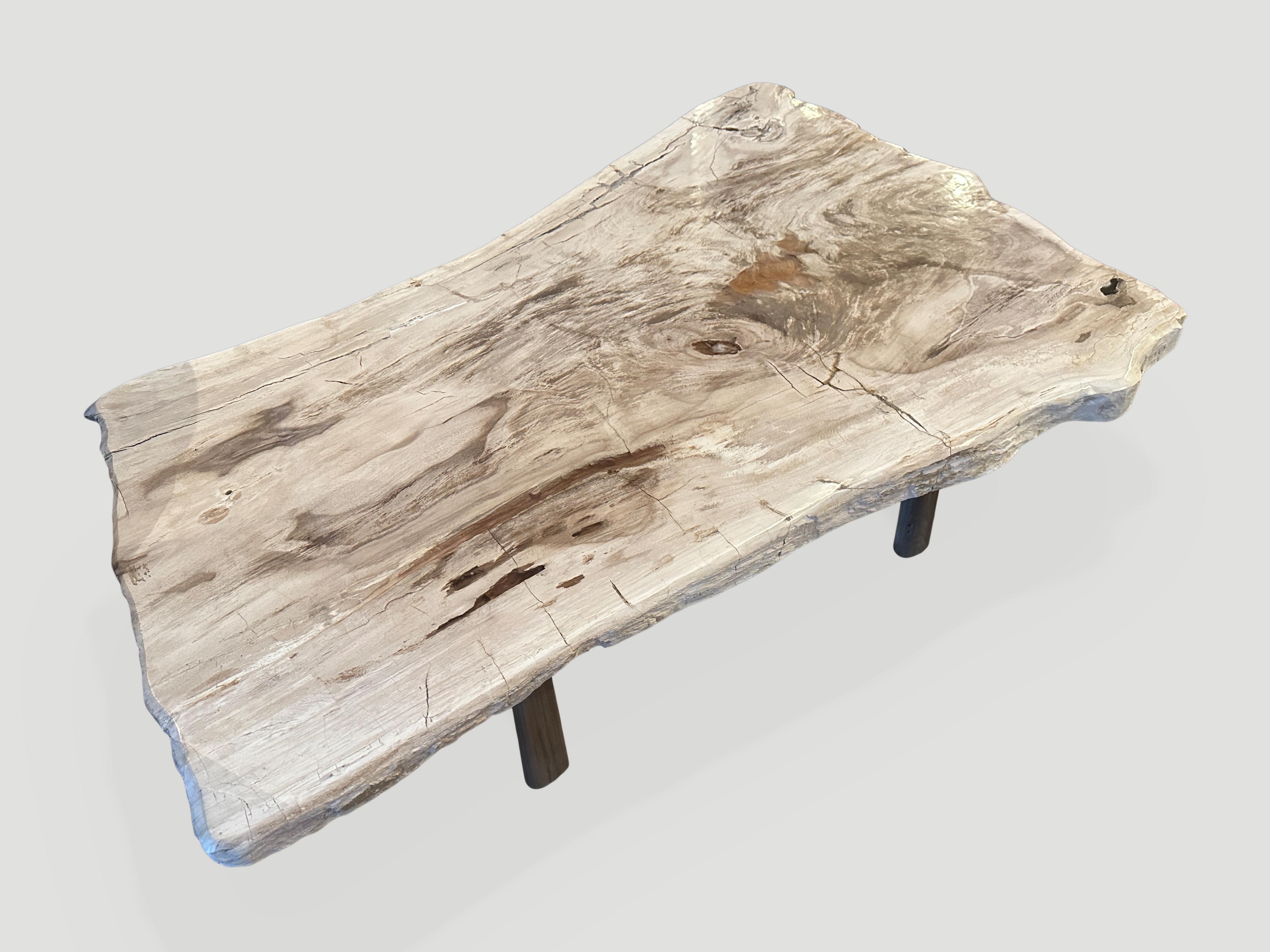 Impressive single two inch slab petrified wood coffee table, resting on a mid century style teak base. These colors are the hardest to source. The live edge varies from 33”-23” wide. We can switch out the base for a different style as shown in the