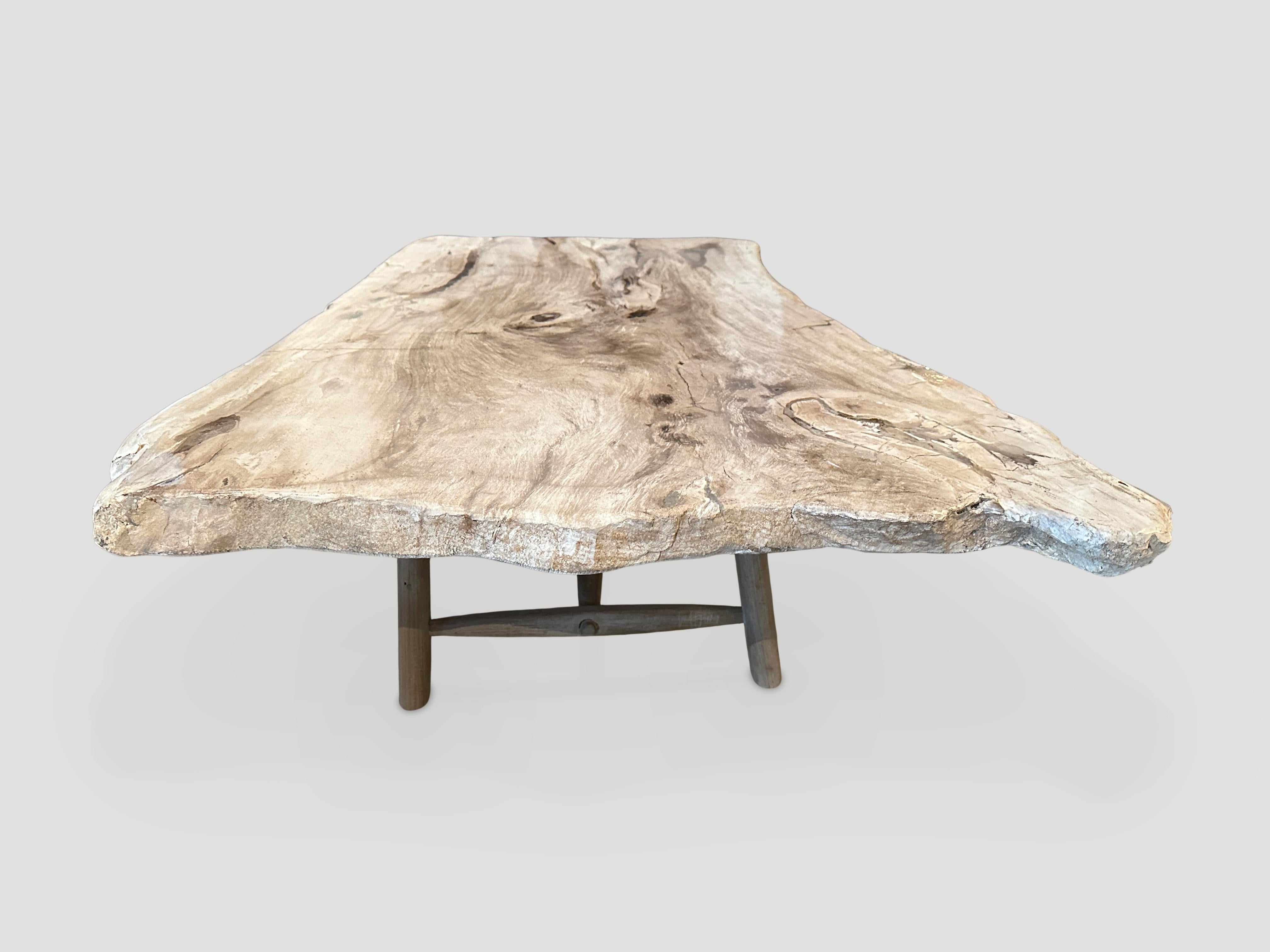 Impressive single two inch thick slab petrified wood coffee table, resting on a midcentury style teak base. These colors are the hardest to source. It’s fascinating how Mother Nature produces these stunning 40 million year old petrified teak logs