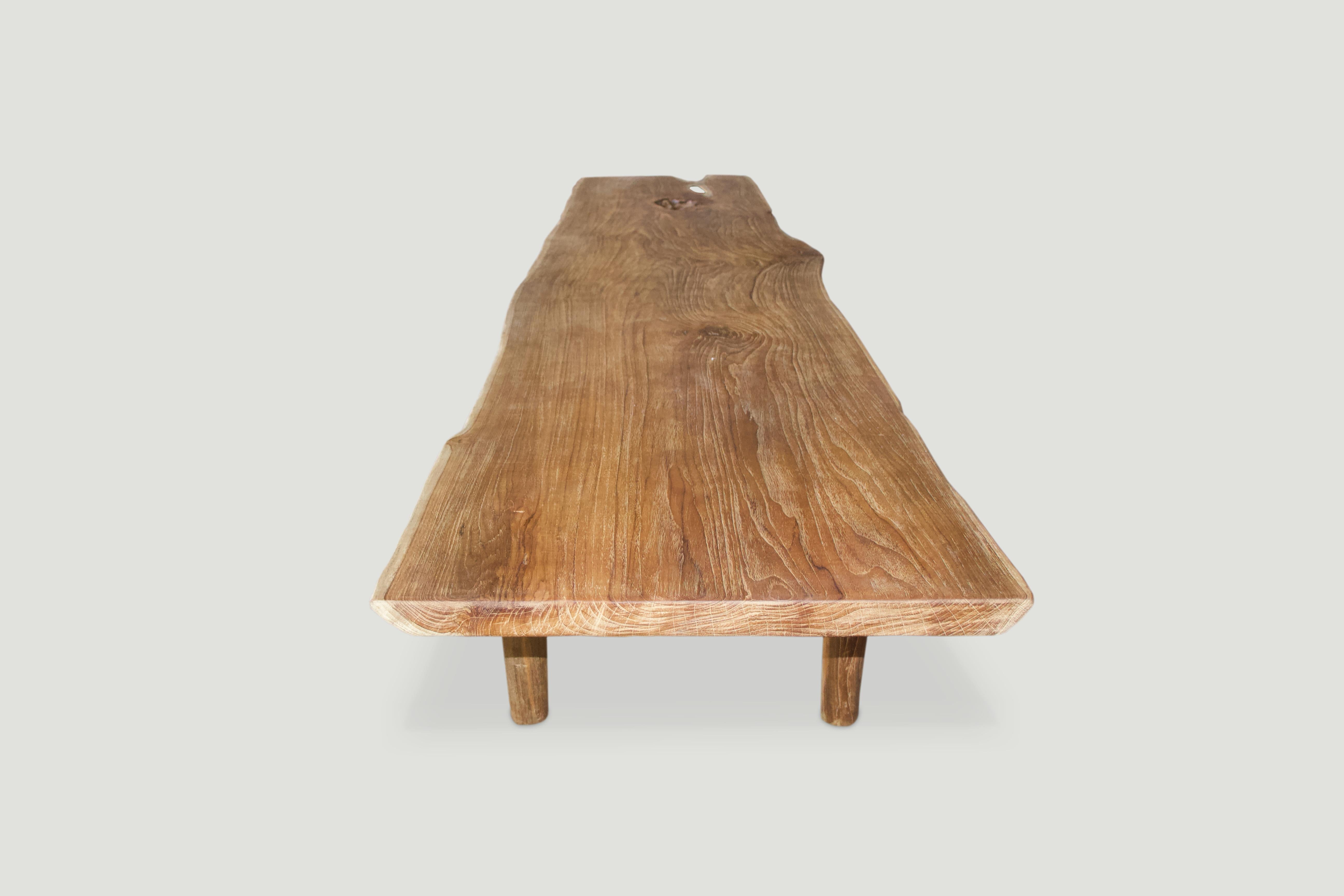 Impressive live edge reclaimed teak coffee table or bench. Stunning grain in this single two inch thick slab with a natural oil finish. We added the minimalist cylinder legs and can also increase the height for a console or dining table. Measures: