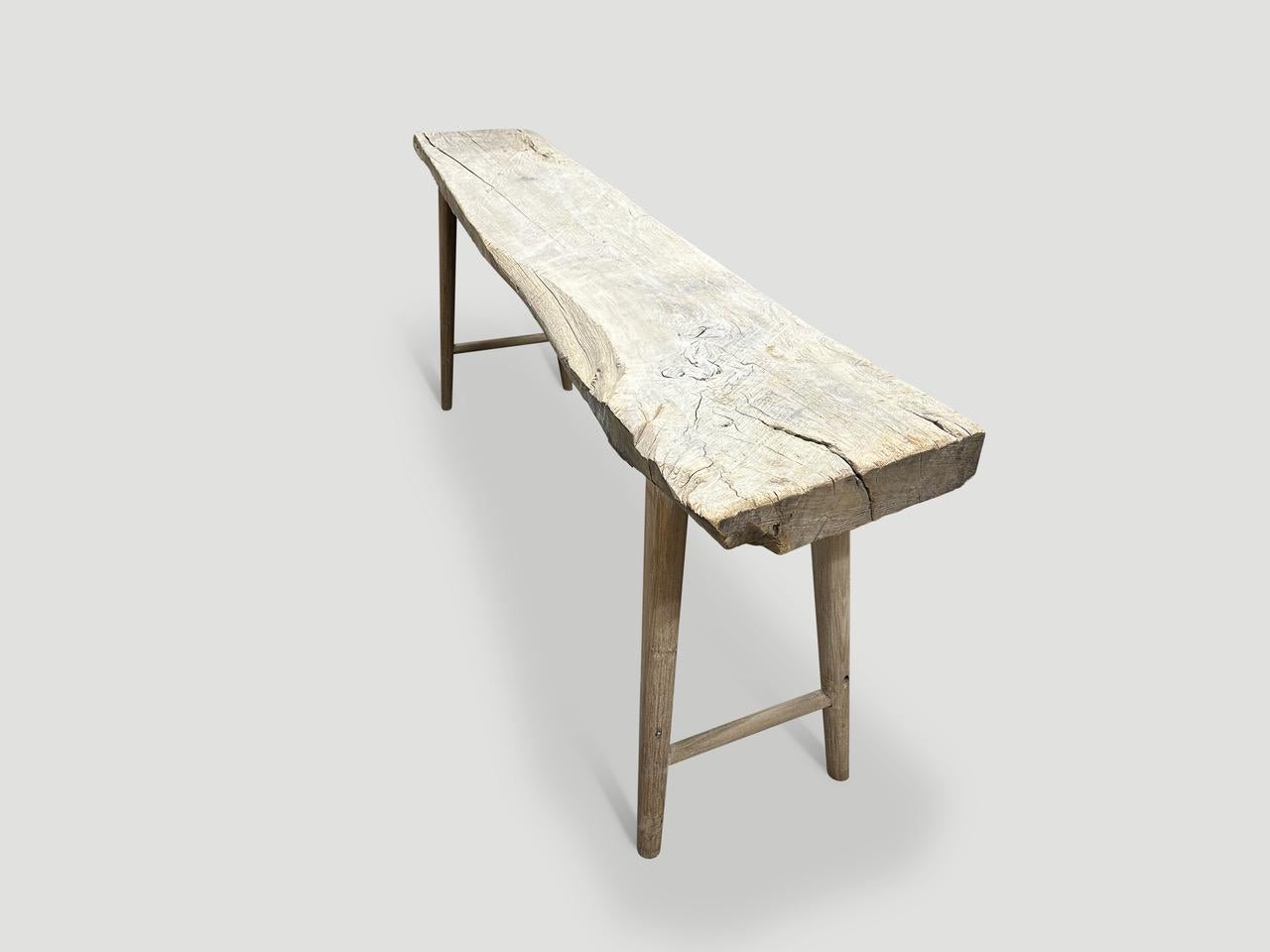 A single thick antique panel with lovely character within the wood. We added smooth teak minimalist legs and butterflies inlaid into the top, to form this beautiful console. First bleached and finished with a light white wash revealing the unique
