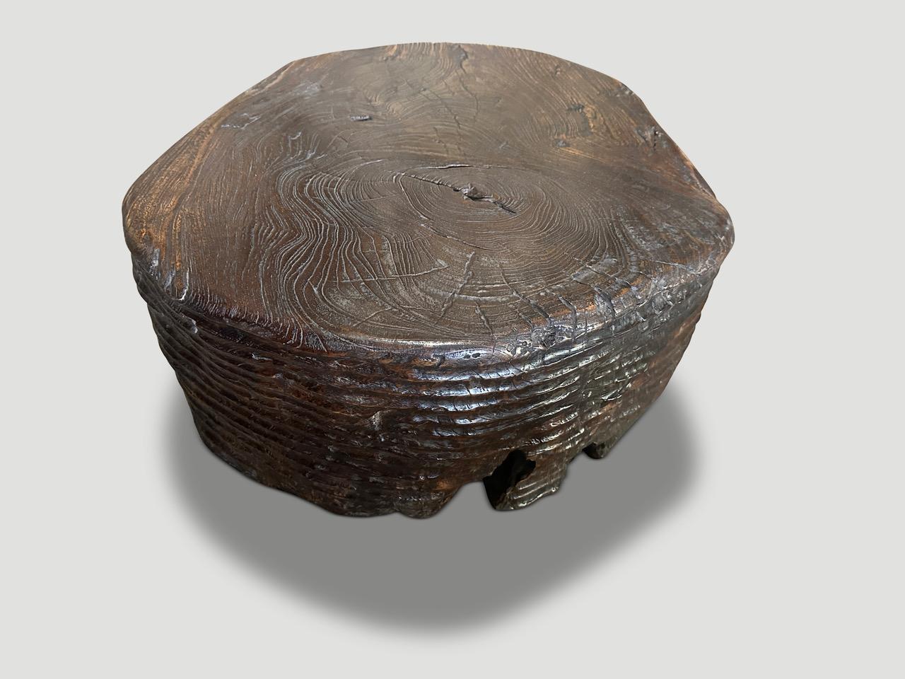 Stunningly beautiful century old teak wood coffee table featuring our unique minimalist carving. The sides of this ancient teak root are hand carved by our master wood carver. We added a chocolate translucent stain revealing the beautiful rare wood