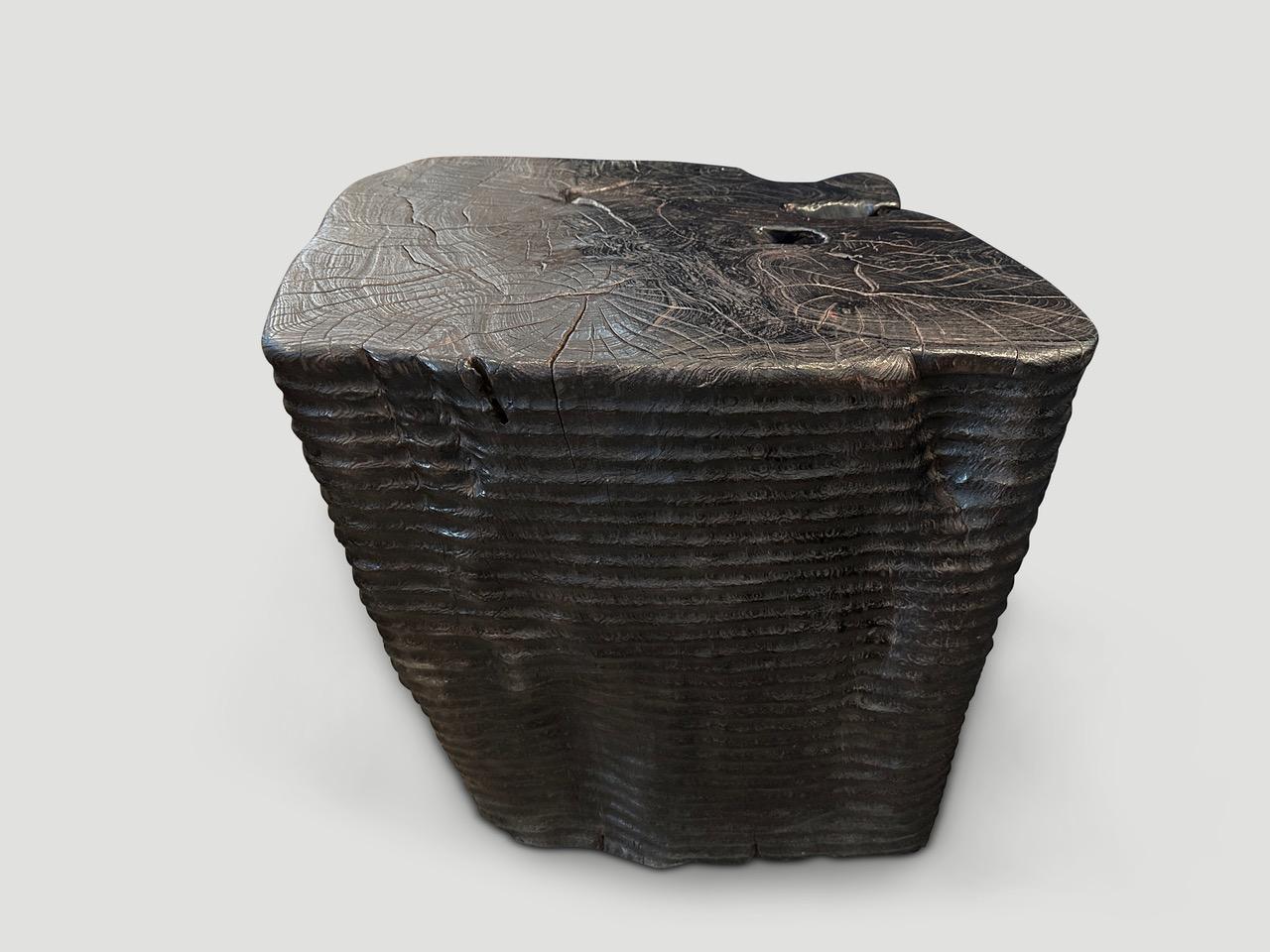 Stunningly beautiful century old teak wood  pedestal or over sized side table, featuring our unique minimalist carving. The sides of this ancient teak root are hand carved by our master wood carver. We added an espresso translucent stain revealing
