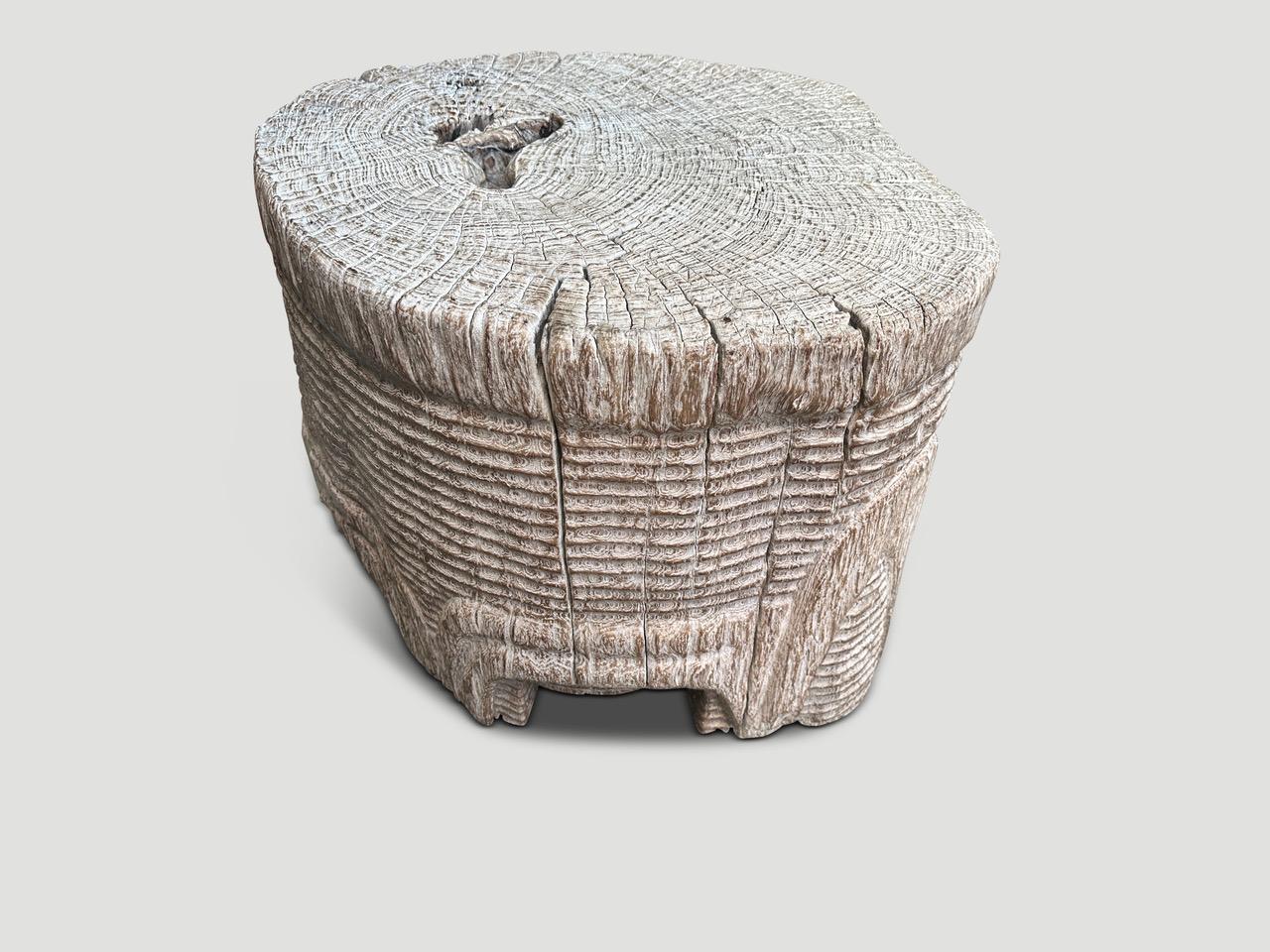 Stunningly beautiful century old teak wood pedestal or over sized side table, featuring our unique minimalist carving. The sides of this ancient teak root are hand carved by our master wood carver. We added a light translucent stain revealing the