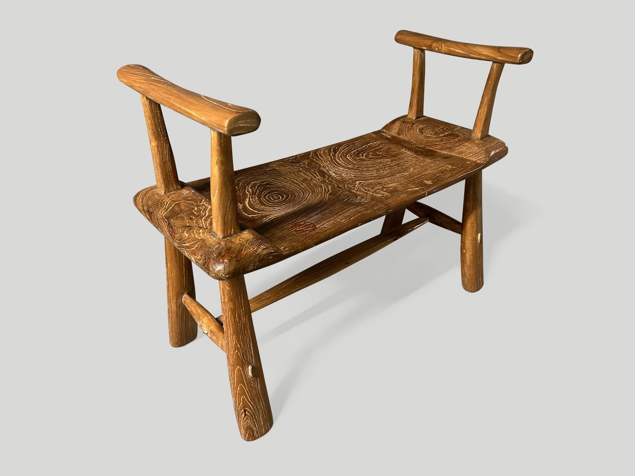 A single thick slab of reclaimed teak wood from my finest collection, is hand carved to produce this one of a kind bench with arms. We added mid century style legs and finished with a natural oil revealing the beautiful wood grain. Part of the Mid