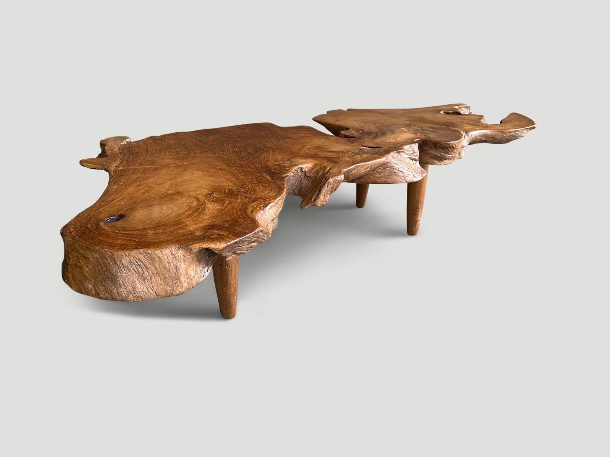 An impressive three inch thick single slab coffee table. Hand made from beautiful reclaimed teak wood, this stunning piece floats on mid-century style conical legs. Organic with a twist. Finished with a natural oil revealing the beautiful wood