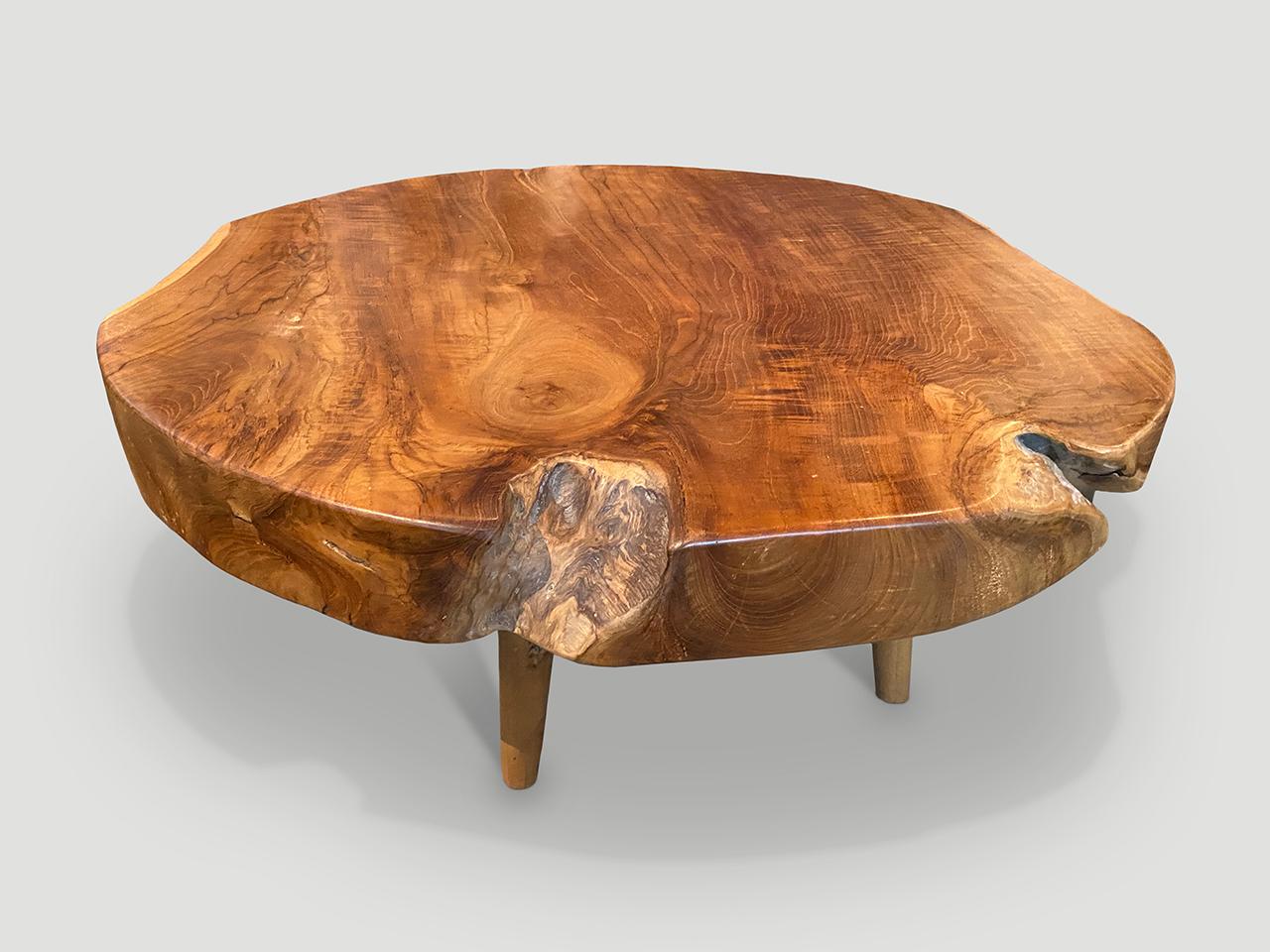 Impressionnante table basse en teck recyclé à une dalle de 3,5 pouces. Il repose sur des pieds coniques de style mi-siècle et est fini avec une huile naturelle qui révèle le magnifique grain du bois. Biologique avec une touche
