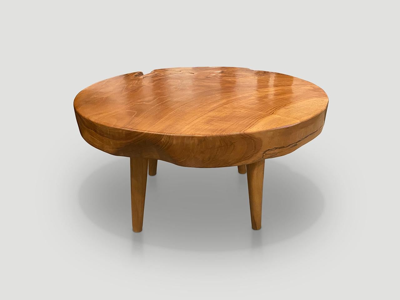 Impressionnante table basse en teck recyclé de 3 pouces à dalle unique. Il repose sur des pieds coniques de style mi-siècle et est fini avec une huile naturelle qui révèle le magnifique grain du bois. Biologique avec une touche d'originalité. Nous