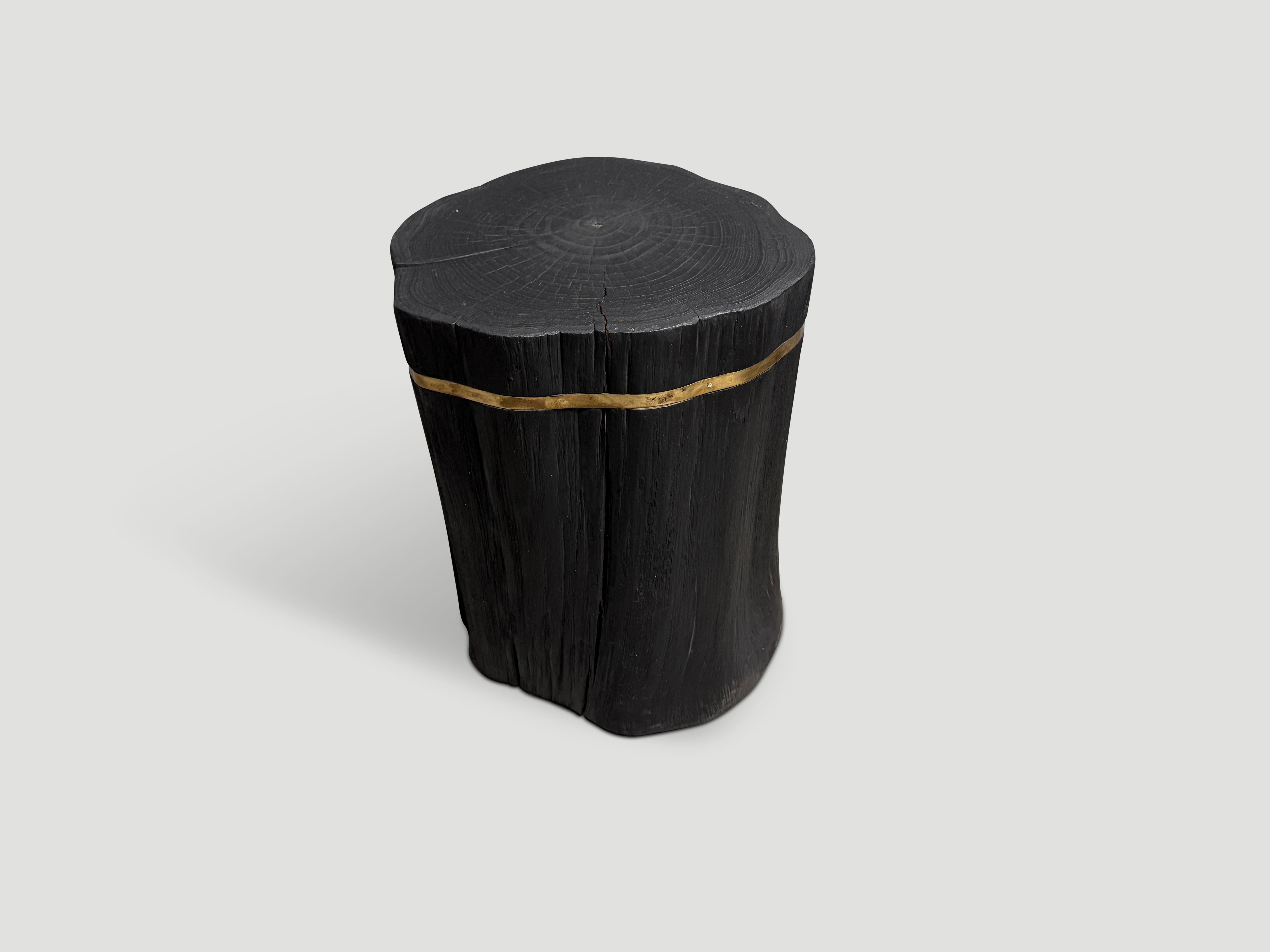 Table d'appoint minimaliste en teck recyclé avec une fine incrustation de bronze.  Chargé, poncé et scellé, il révèle les magnifiques veines du bois. Également disponible avec incrustation en argent.

La collection Triple Burnt représente une ligne