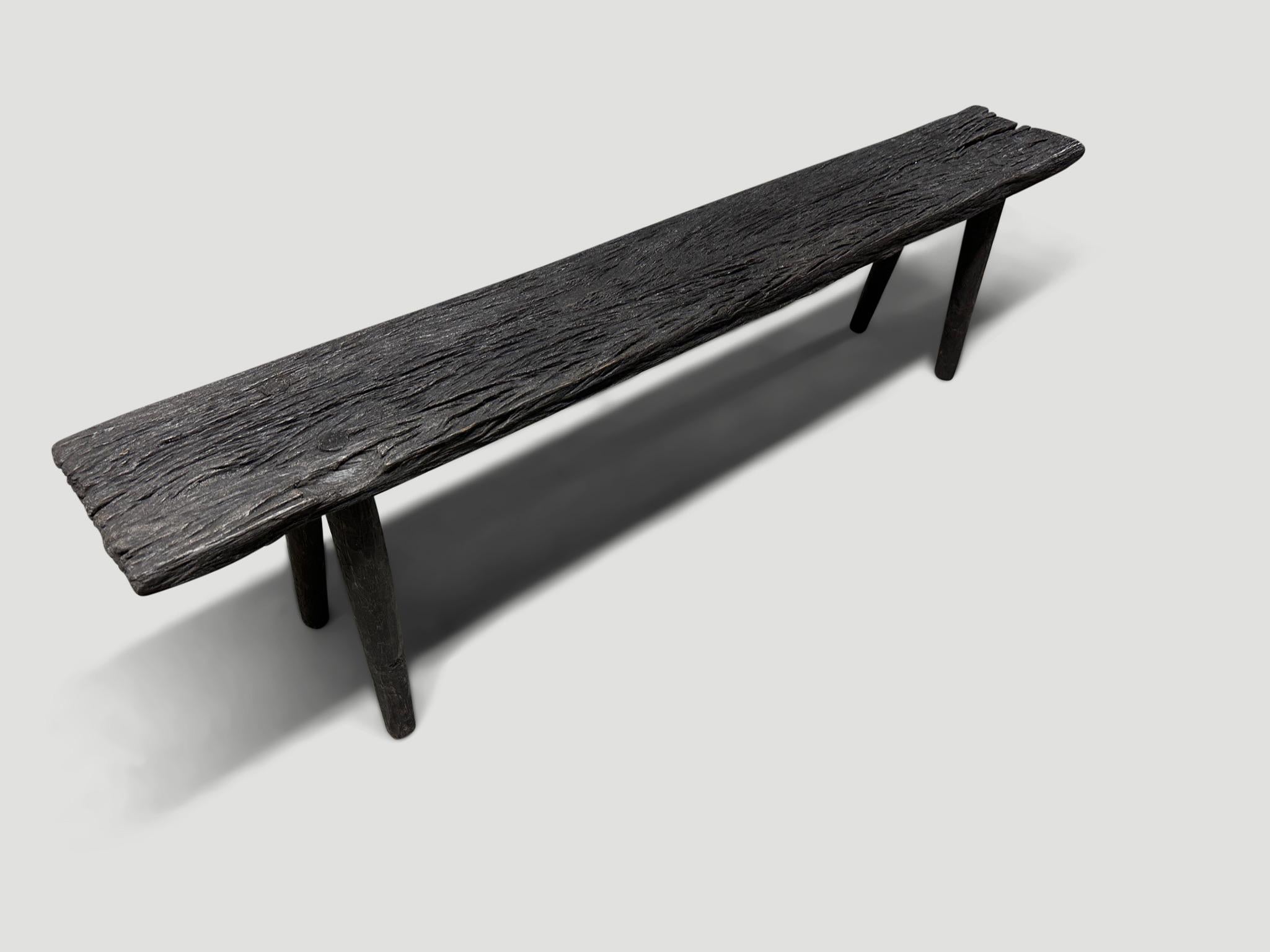 Schöne minimalistische Eisenholzbank, auch bekannt als Ulin-Holz. Gekohlt, geschliffen und versiegelt, wobei die schöne Holzmaserung zum Vorschein kommt. Wir haben minimalistische Beine aus glatten Teakholzzylindern hinzugefügt. Es kommt auf die