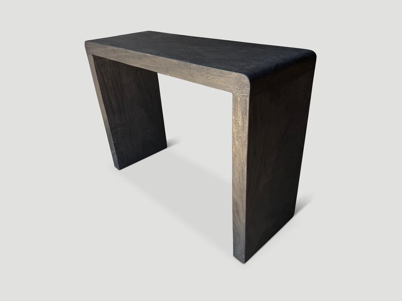 Minimalist console table made from suar wood with an impressive three inch thick top and legs. Charred sanded and sealed revealing the beautiful wood grain. It’s all in the details. Custom stains and sizes available. Please inquire. 

The Triple