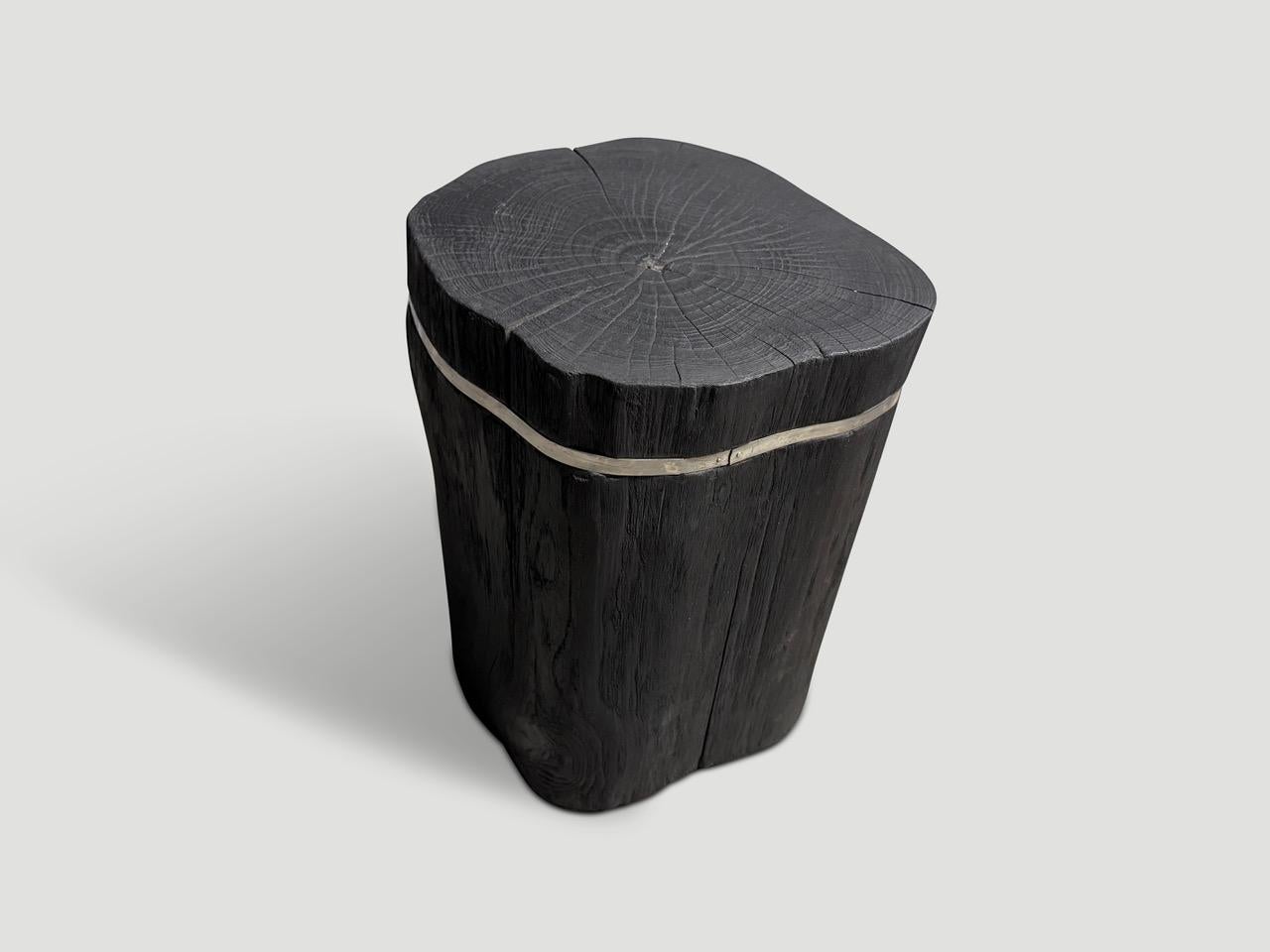 Table d'appoint minimaliste en bois de teck récupéré avec une fine incrustation en acier inoxydable argenté. Chargé, poncé et scellé, il révèle les magnifiques veines du bois. Également disponible avec une incrustation en bronze.

La collection