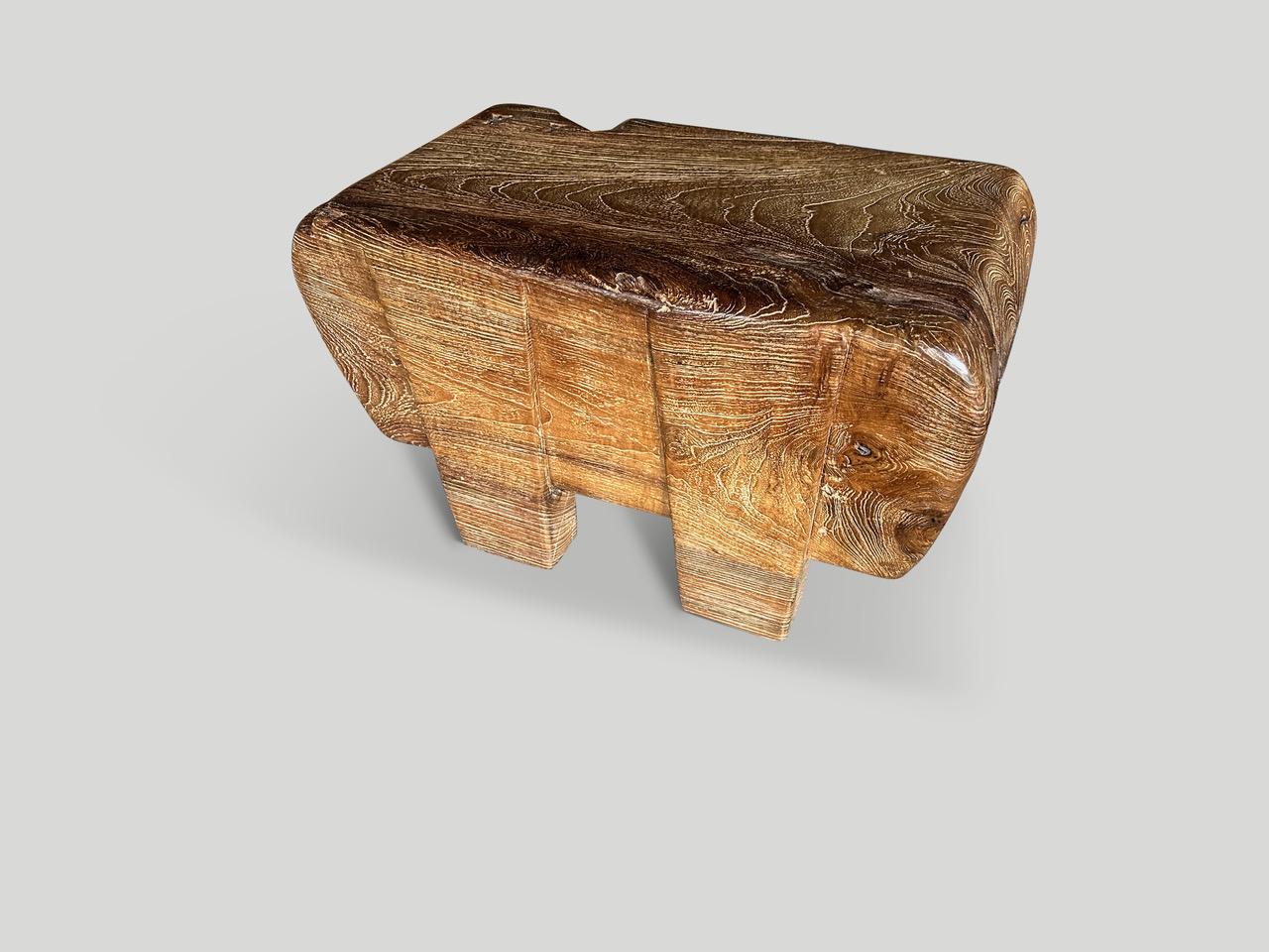An impressive eleven inch thick teak log floats five inches off the floor on minimalist cut out legs. This one of a kind piece can be used as a small coffee table, side table or bench. We added butterflies inlaid into the top. Finished with a