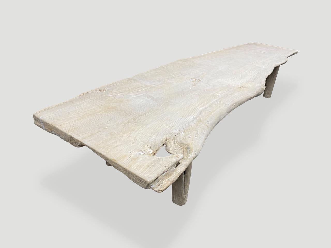 Reclaimed teak wood bench or coffee table. We bleached the wood first and then added a light white wash exposing the beautiful grain of the wood. Finally we added minimalist cylinder legs. This live edge single panel width varies from 26” in the