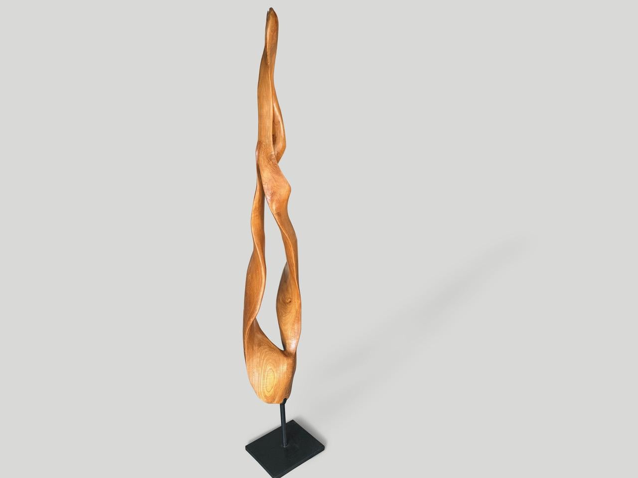 Impressionante scultura minimalista scolpita a mano da un unico pezzo di legno di mogano recuperato. Abbiamo aggiunto un olio naturale che rivela le bellissime venature del legno. Poggia su una moderna base in metallo nero larga 10″ e profonda
