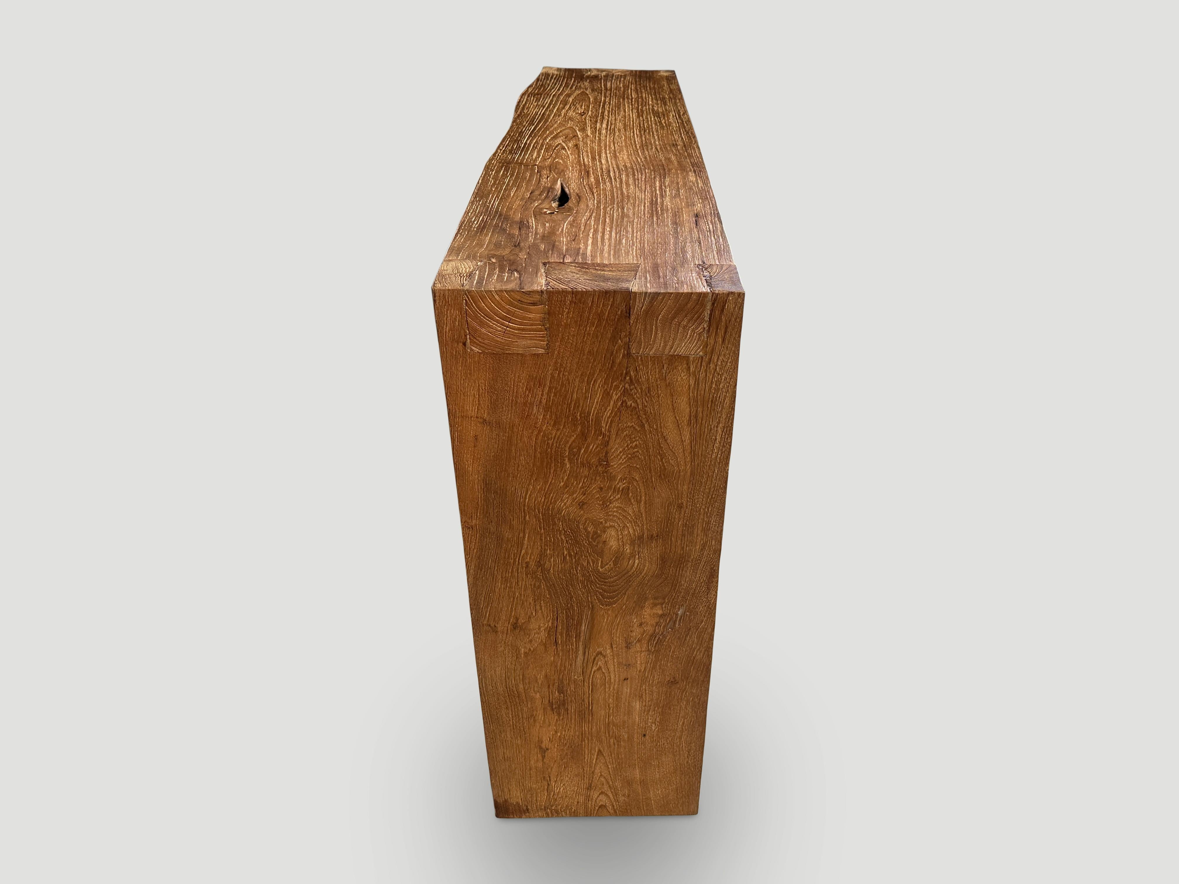 Impressive three inch thick minimalist console table hand made from reclaimed teak wood. One side is straight and the other side has a light live edge. Finished in a natural oil revealing the beautiful wood grain. Custom stains and sizes