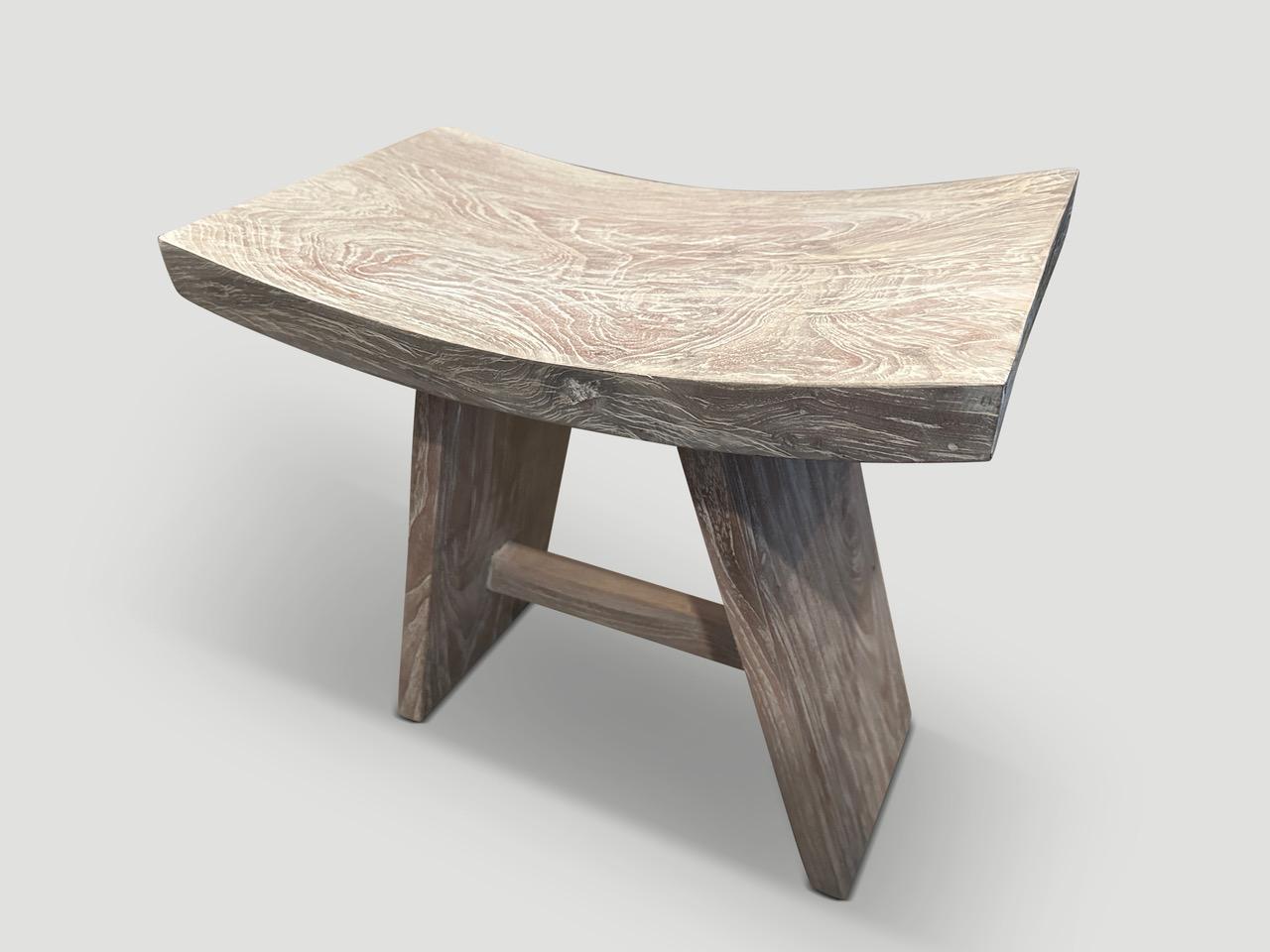 Sleek Minimalist bench or stool handmade from a single slab of reclaimed teak with a cerused finish revealing the beautiful wood grain. We have a collection. The images reflect one. Full dimensions; 19.5 x 11.5 x 17.5? high at center x 18.5? high at