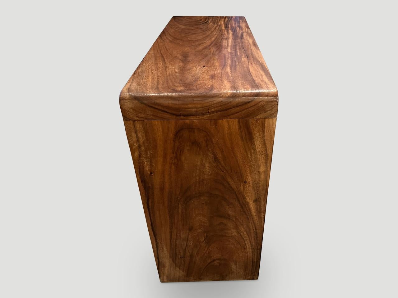 Impressive minimalist console table hand made from reclaimed Suar wood with butterfly detail on the leg, as shown in the final images. Each panel is three inches thick. Finished in a natural oil revealing the beautiful wood grain.
Custom stains and
