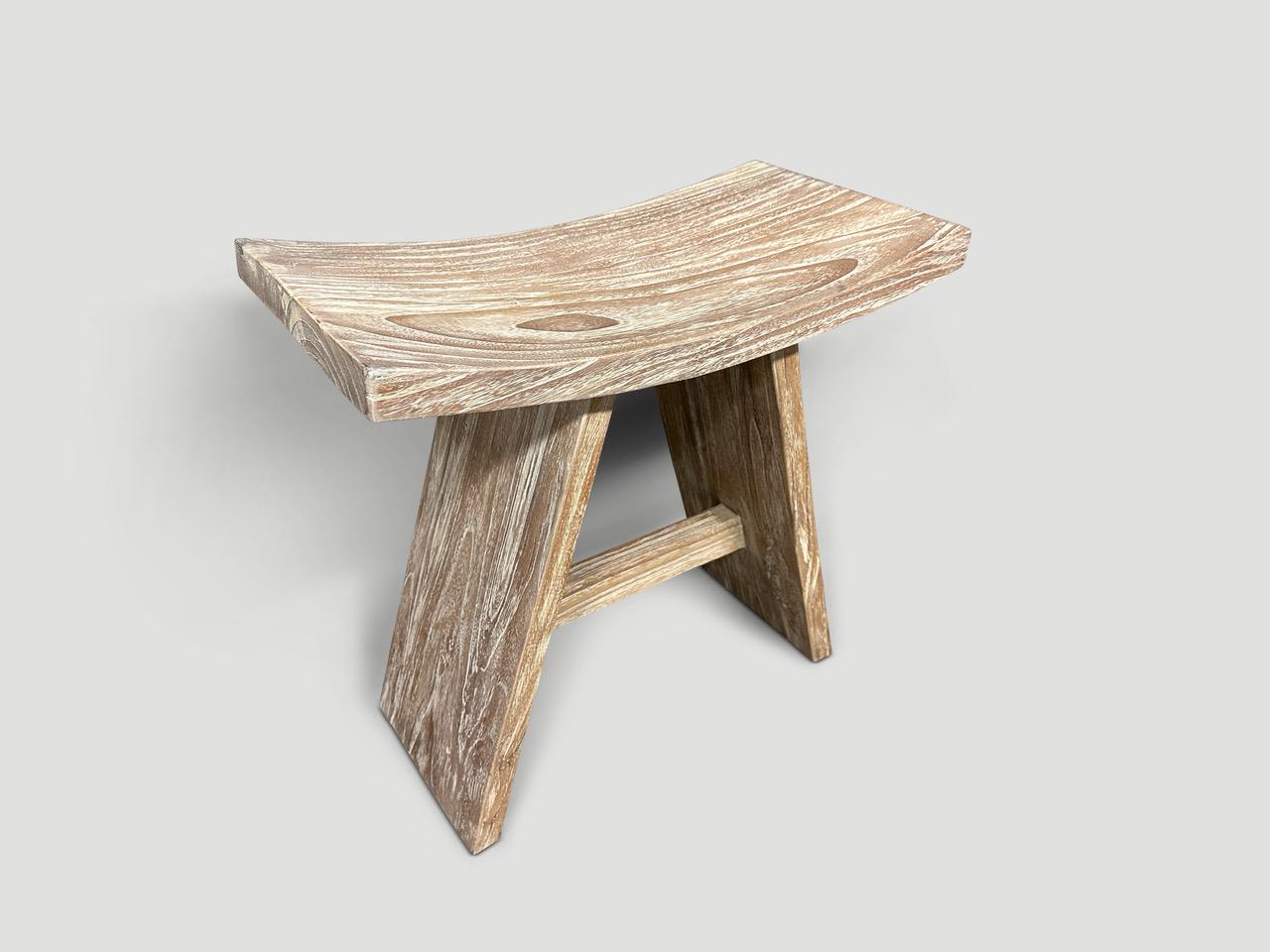 Sleek minimalist bench or stool hand made from a single slab of reclaimed teak wood with a cerused finish revealing the beautiful wood grain. We have a collection. The images and price reflect the one shown. Full dimensions; 19.5” wide x 10.5” deep
