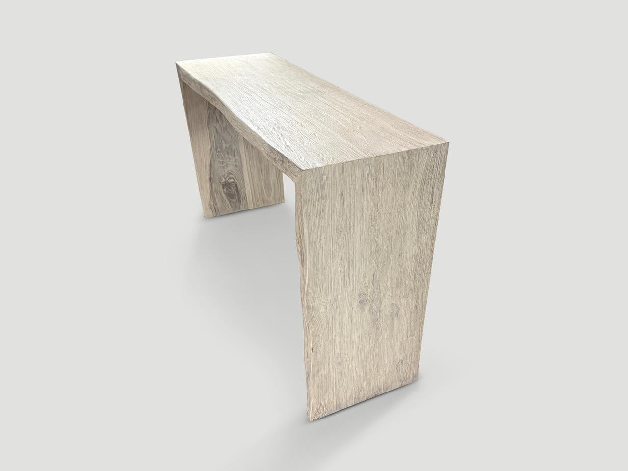 Impressive two inch thick minimalist console table hand made from reclaimed teak wood. One side is straight and the other side has a light live edge. Finished with a white wash and cerused revealing the beautiful wood grain. Full dimensions; 60”
