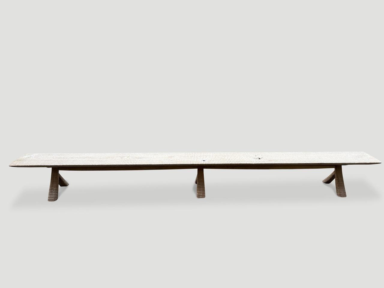 A beautiful thick panel of rare teak wood, taken from my finest collection was meticulously hand carved by our master carver to produce this impressive bench for our Mid- Century Couture Collection. We added a translucent bone stain revealing the