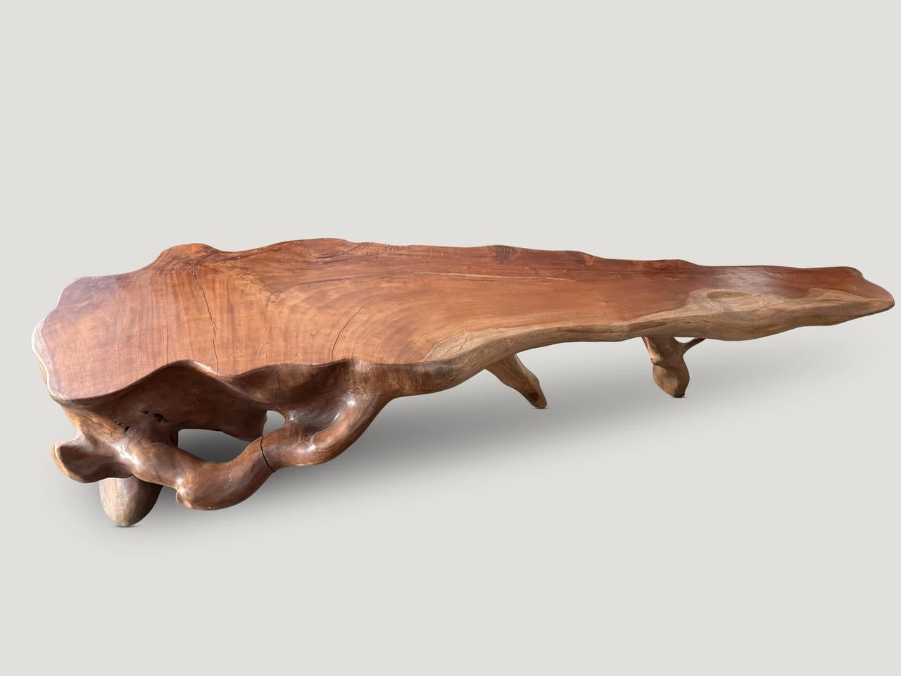 An impressive organic monumental console table carved from a single piece of mahogany wood over a hundred years old. Both sculptural and usable this one of a kind piece awaits a hotel project, residential lobby or a large residence. Finished with a