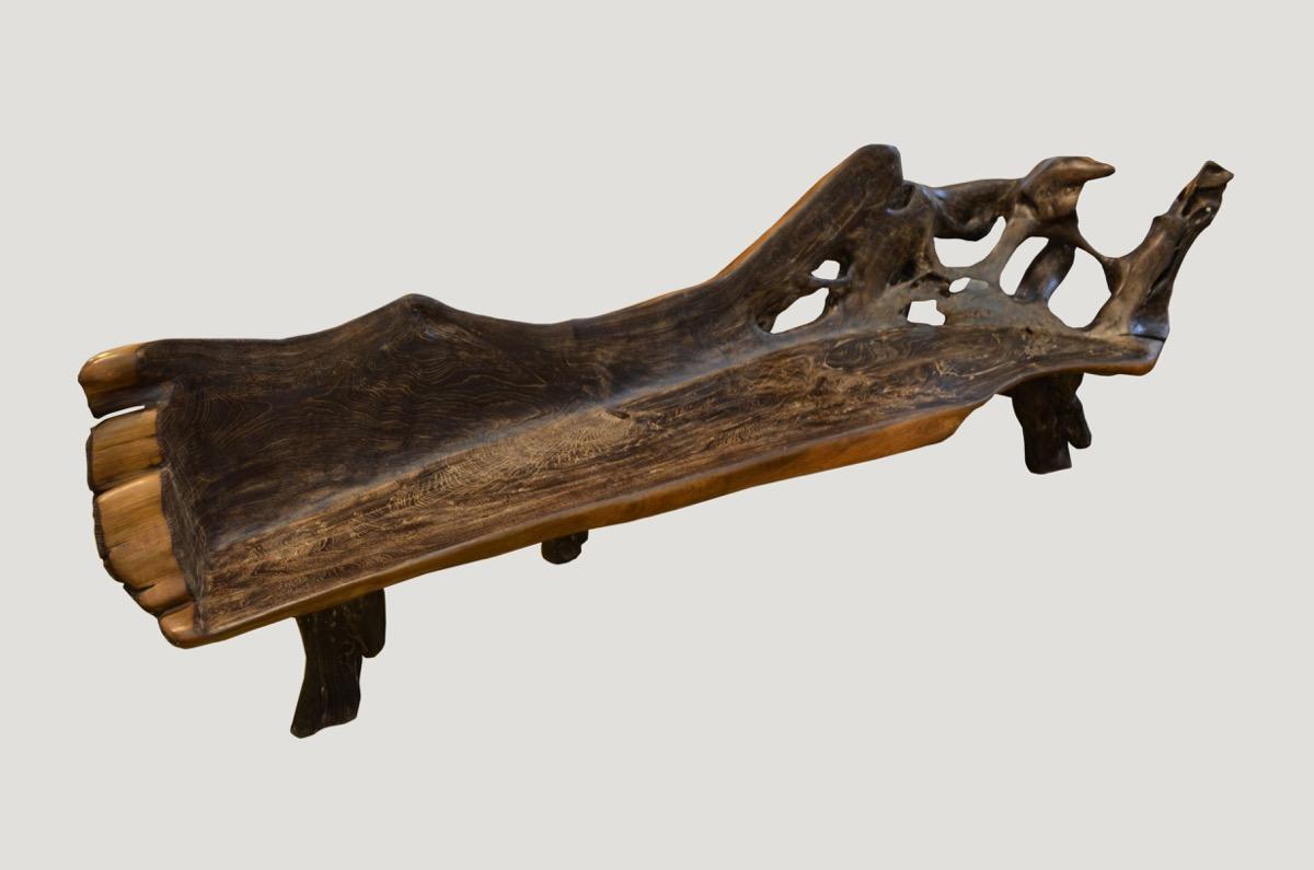 Organic shaped reclaimed teak bench carved from an impressive single root found in the jungle in Sumatra. We added the legs, burnt it one time and finally added a cerused finish. The sides are left natural teak and polished in contrast. Organic is