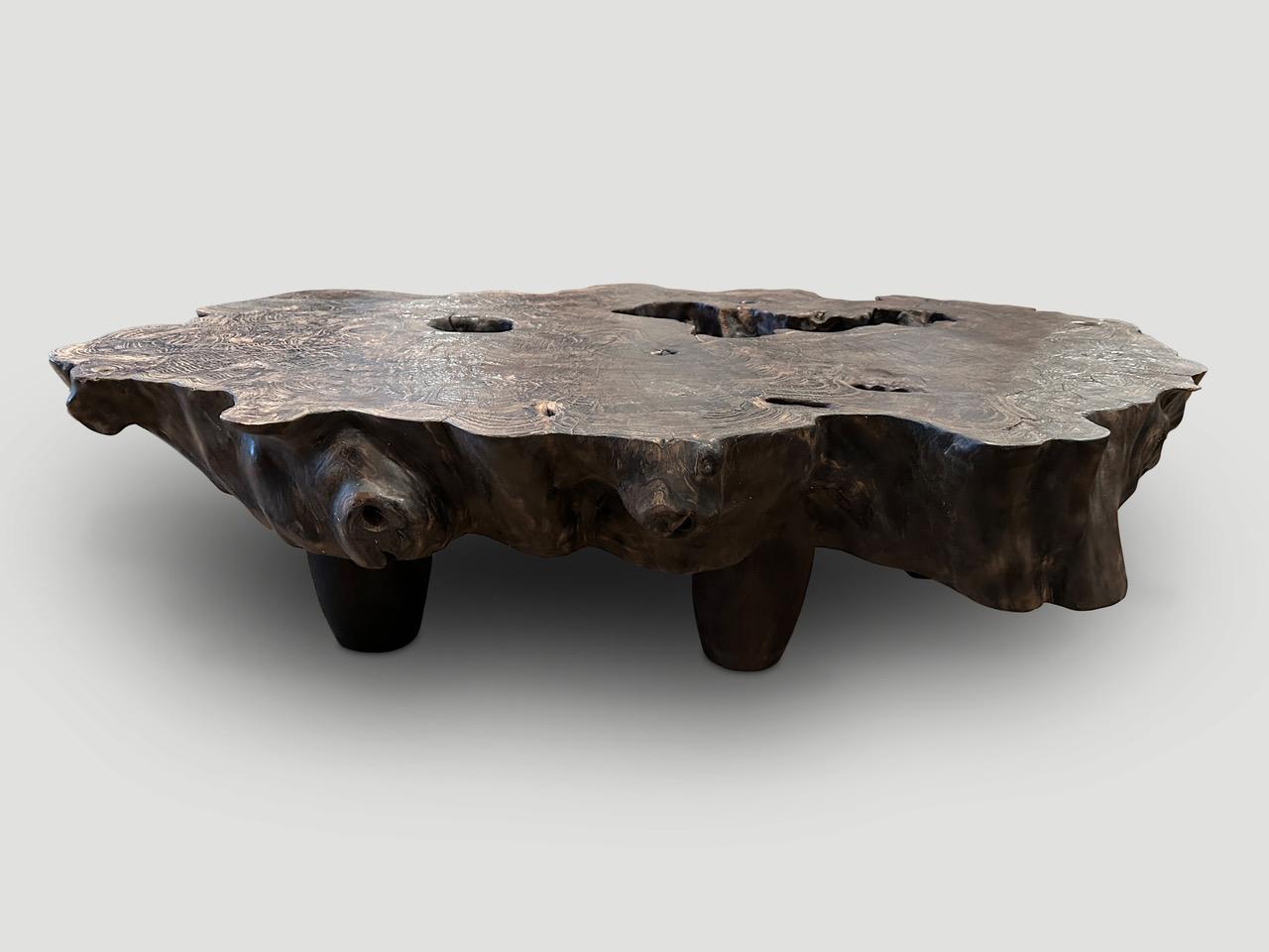 Natural organic formed reclaimed teak root coffee table. We added cone style legs and charred this impressive six inch slab lightly to a rich brown. Finally we rubbed the top with a wire brush revealing the beautiful wood grain. It’s all in the