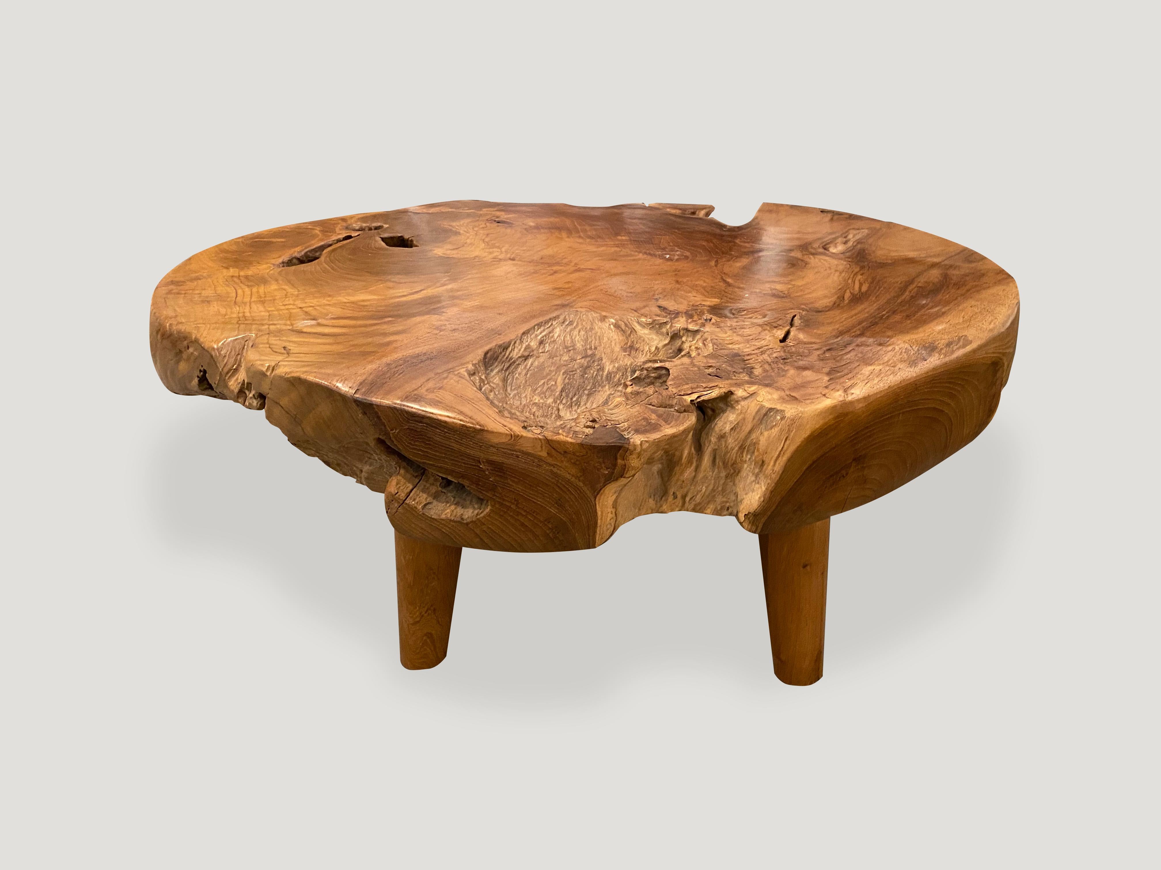 Impressive four inch thick natural teak wood coffee table carved from a single log. Floating on midcentury style cone legs. Organic with a twist. We have a collection. The size and price reflect the one shown.

Own an Andrianna Shamaris