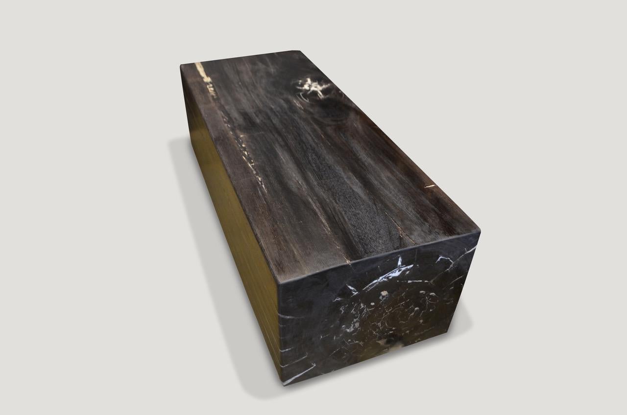 High quality super smooth petrified wood log bench. Stunning charcoal grey, black and contrasting white tones make this an impressive piece for any space. Floating on two espresso stained wooden bases which can be modified for a different height.