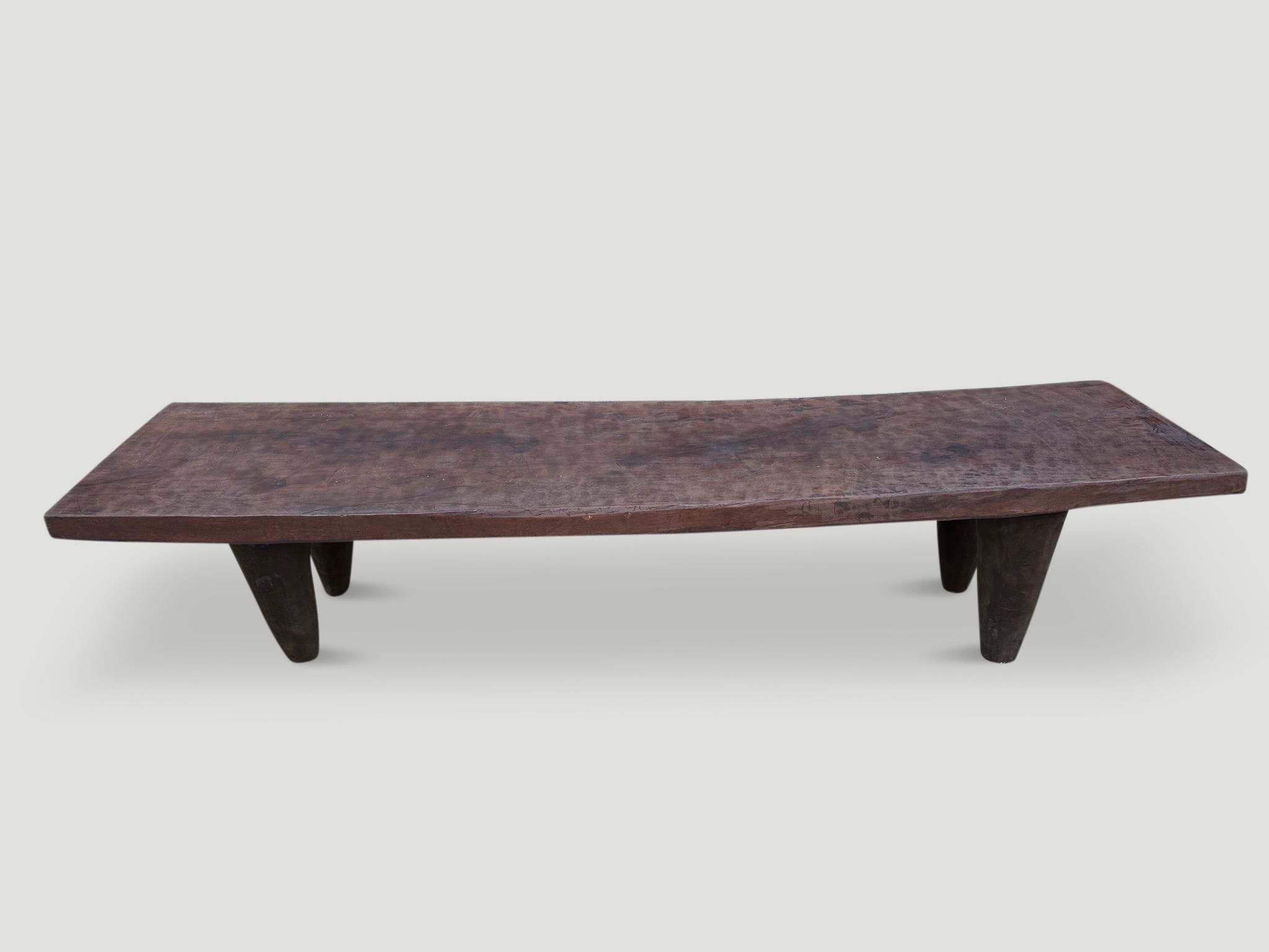 Rare antique coffee table or bench hand carved by the Senufo tribes from a single block of Iroko wood, native to the west coast of Africa. The wood is tough, dense and very durable. Shown with carved cone style legs. We only source the best. This