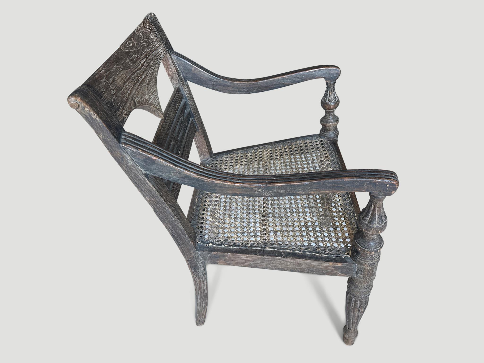 Stunning hand carved teak arm chair with beautiful patina. The front legs and arm rests are beautifully fluted and hand carved. We have a collection of four all one of a kind. The price and images reflect the one shown. Full dimensions;  20