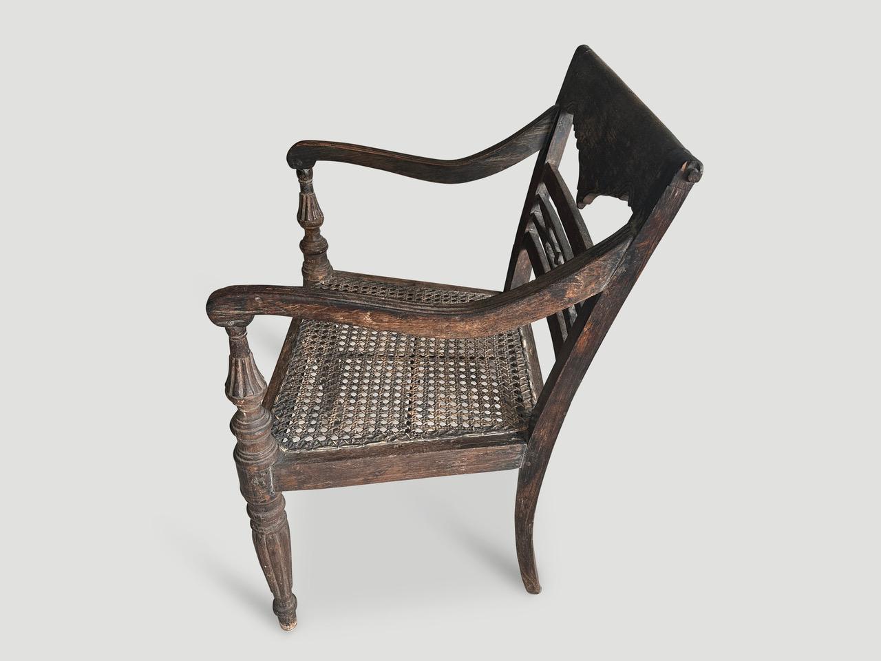 Stunning hand carved teak arm chair with beautiful patina. The front legs and arm rests are beautifully fluted and hand carved. We have a collection of four all one of a kind. The price and images reflect the one shown. Full dimensions; 20.5” wide