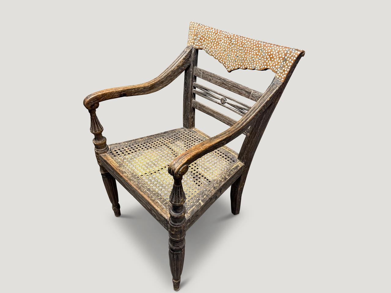 Impressive hand carved teak arm chair with beautiful patina. The front legs and arm rests are fluted and hand carved. We added shell inlay onto the back rest. Full dimensions; Front 20″ wide x back 15” wide x 17.5” deep x seat 16″ high x back rest