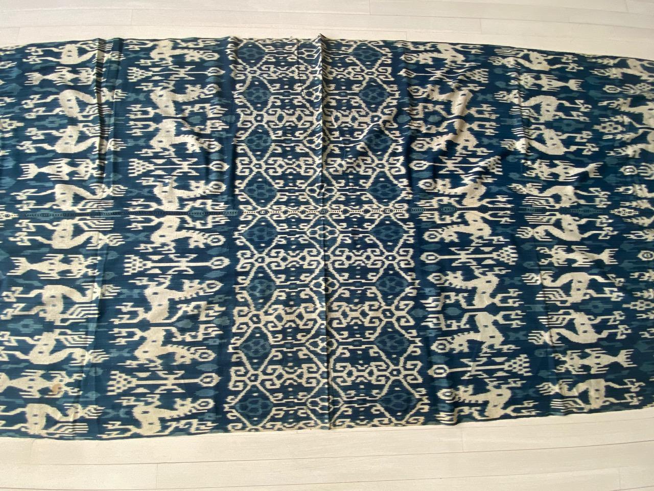 Beautiful soft indigo Ikat, with stunning long tassels, from Sumba. Fabulous on a sofa, bed or even to wear as a shawl. Mythical characters, lizards, horses and birds intermingle in this graphic cloth from Sumba. Ikat is an ancient technique which