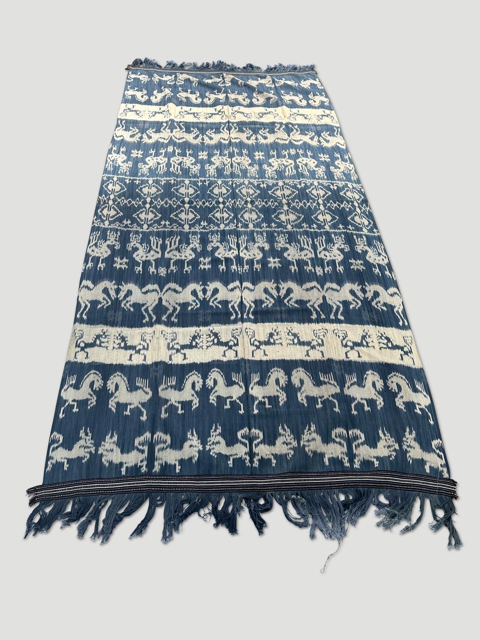 Bellissimo e morbido Ikat su questo raro tessuto bianco e indaco proveniente da Sumba. Favoloso sul divano, sul letto, appeso alla parete o anche da indossare come scialle. Personaggi mitici, lucertole, cavalli e uccelli si mescolano in questa tela