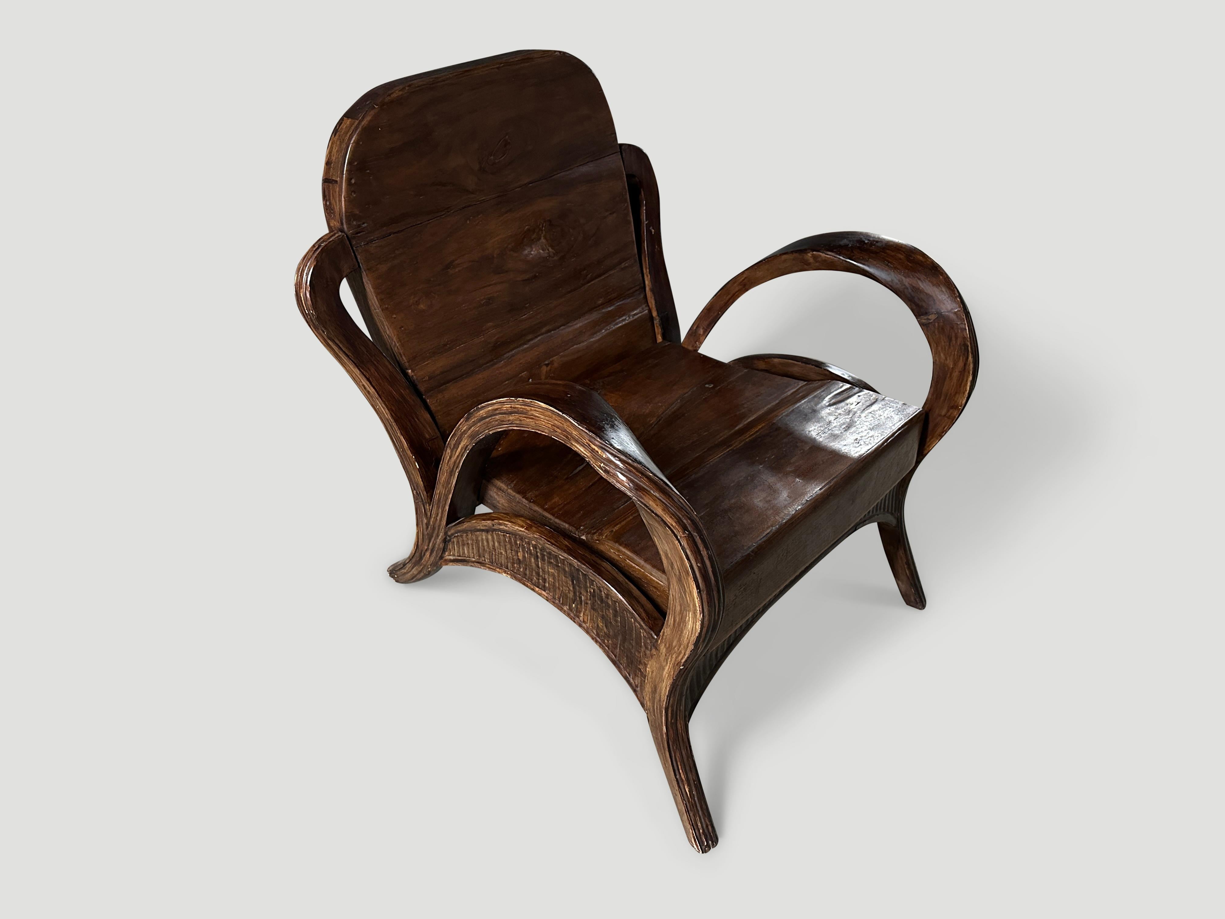 Ce fauteuil en teck de Sumatra est doté d'accoudoirs inhabituels sculptés à la main et polis à l'extrême. Vers 1950. Dimensions complètes ; Accoudoir à accoudoir 27″ de large x Jambe à jambe 30″ de profondeur x siège 16
