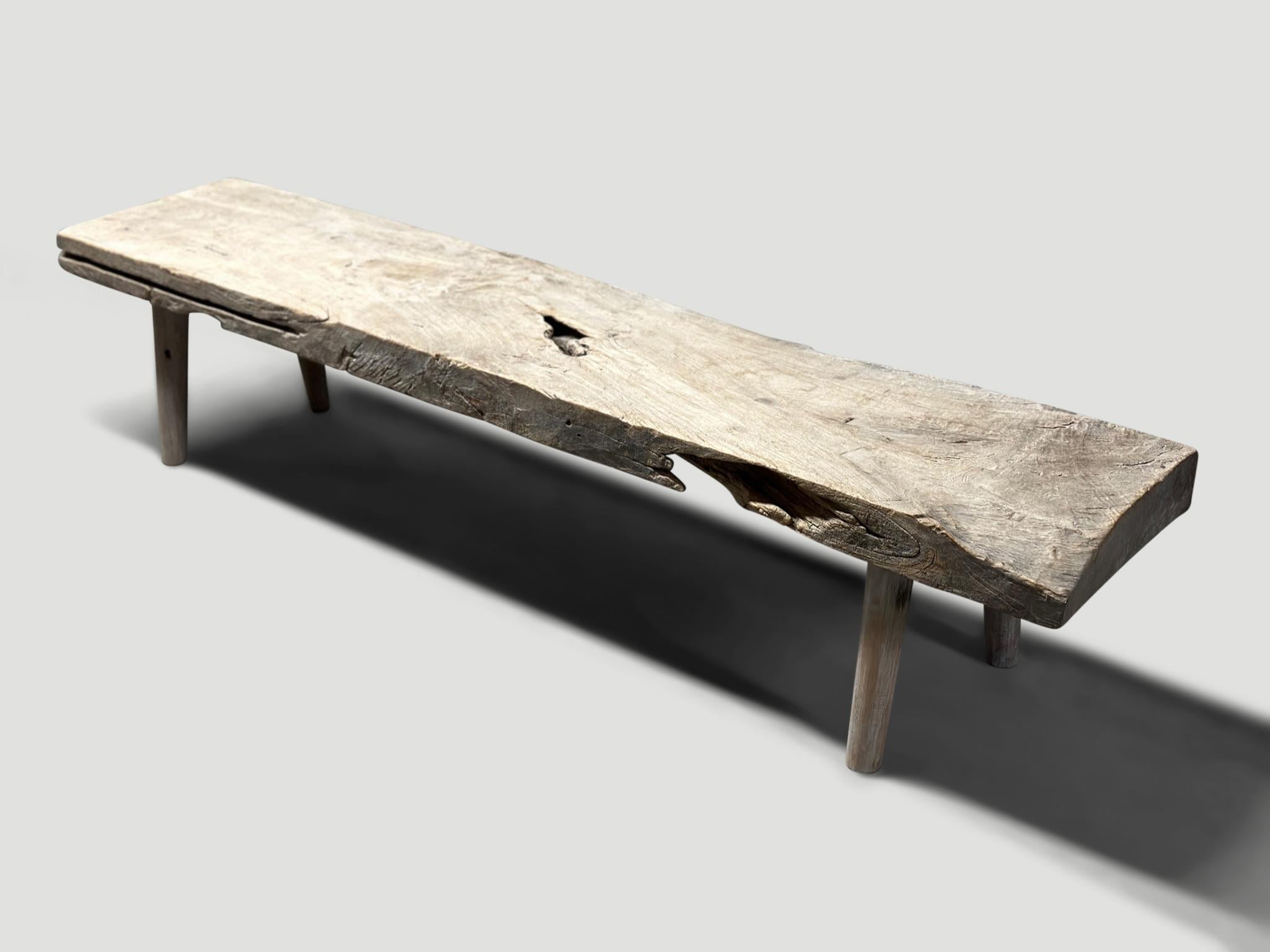 Impressive three inch thick teak bench in pale wood tones, resembling stone. Beautiful details in this 100 year old wood. We added minimalist cylinder legs. Both usable and a piece of art. Rare.

This bench was hand made in the spirit of Wabi-Sabi,