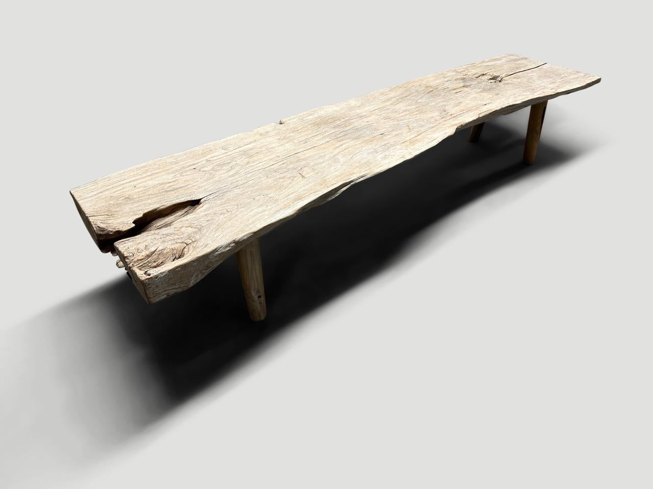Impressive, live edge two inch thick teak wood bench in pale wood tones, resembling stone. Beautiful details in this 100 year old wood. We added minimalist cylinder legs. Both usable and a piece of art. Rare. Full dimensions; 80