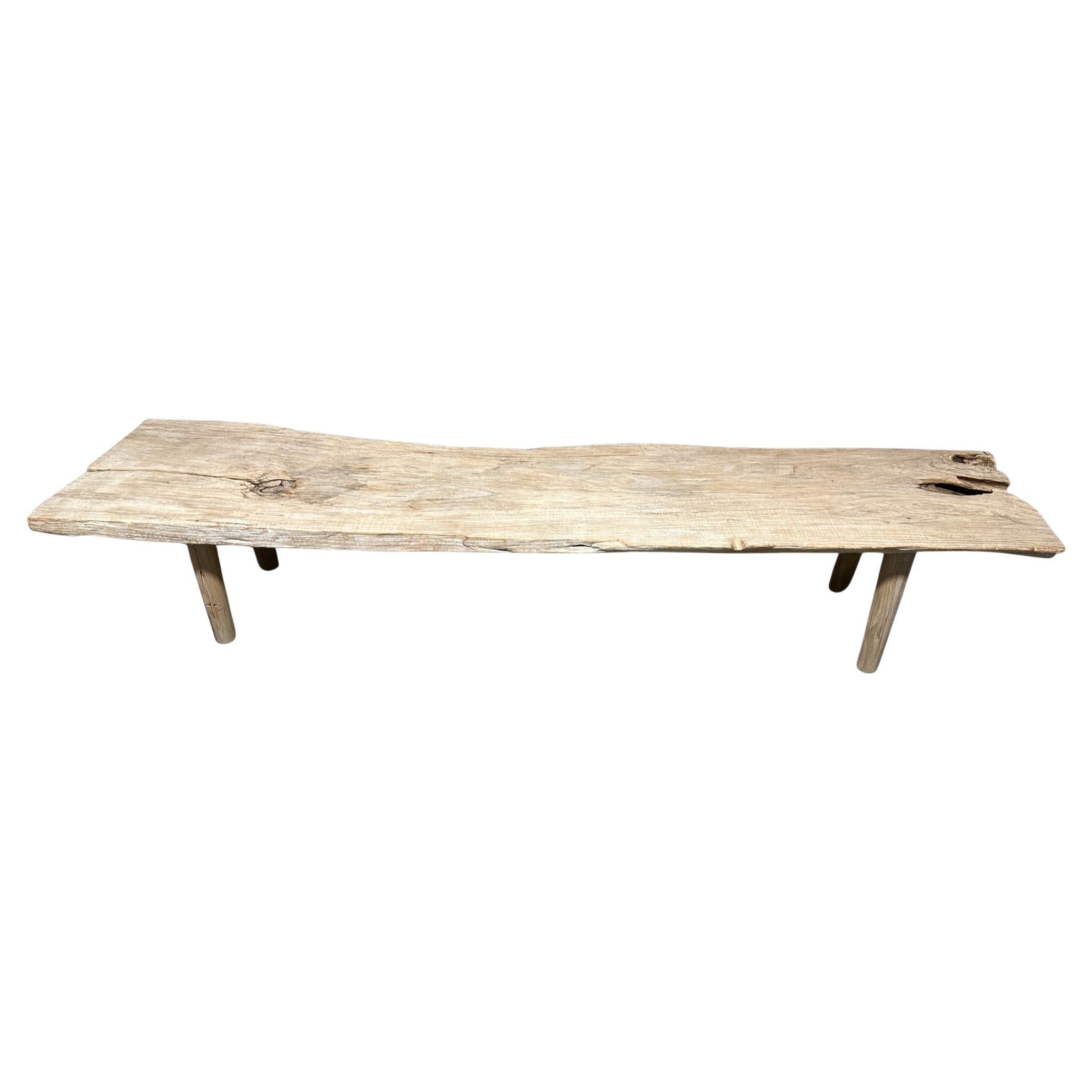 Impressionnant banc en bois de teck de deux pouces d'épaisseur dans des tons de bois pâle, ressemblant à de la pierre. Les détails de ce bois centenaire sont magnifiques. Nous avons ajouté des pieds cylindriques minimalistes. A la fois utilisable et